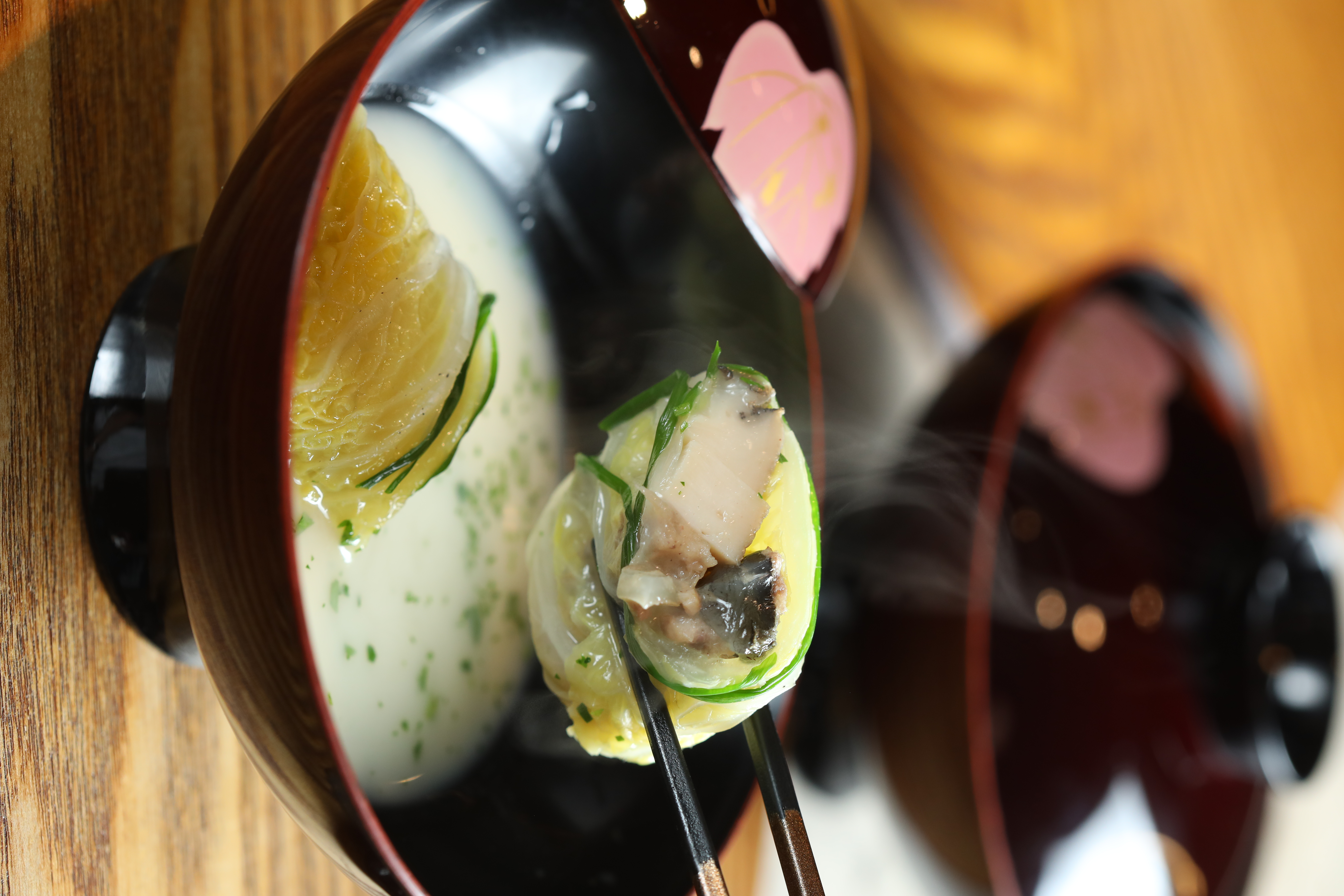 夏日套餐中的重頭戲「鮑魚」，是用大白菜包裹雲林養殖的甲魚和切片鮑魚，底下是龍膽石斑熬成的奶白魚湯，蔬菜與海味形成「1+1>2」的鮮味加乘。（1,880元套餐菜色）