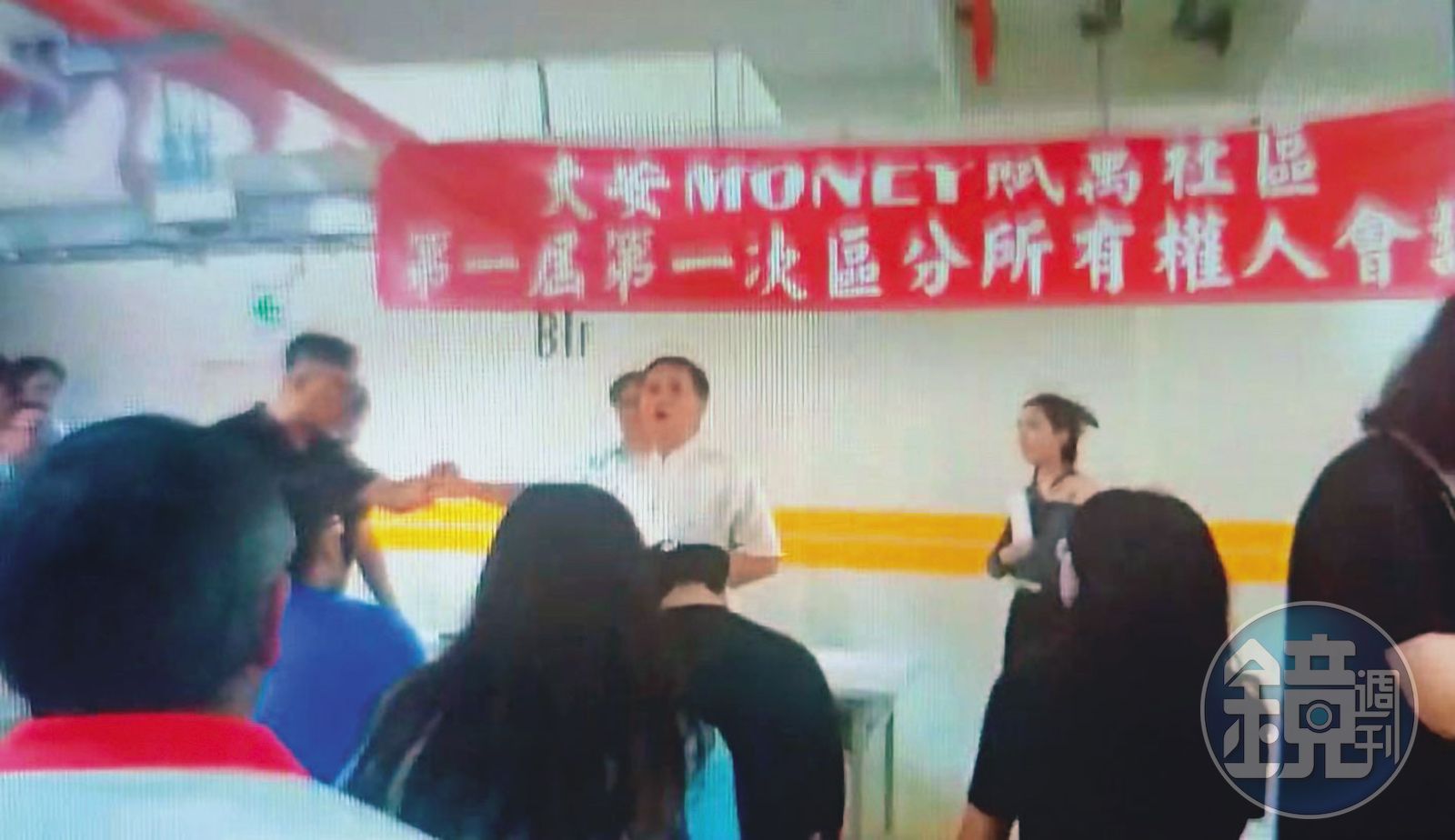 劉進明（白衣者）在區權會質疑公安問題，與恆合建設代表爆發口角、拉扯。（讀者提供）