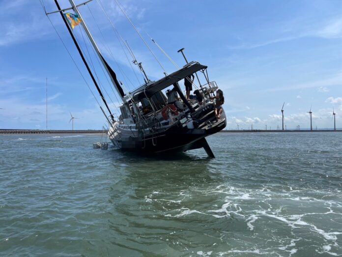 「光腳號」帆船擱淺傾斜9小時，所幸人員均安。（翻攝記者爆料網）