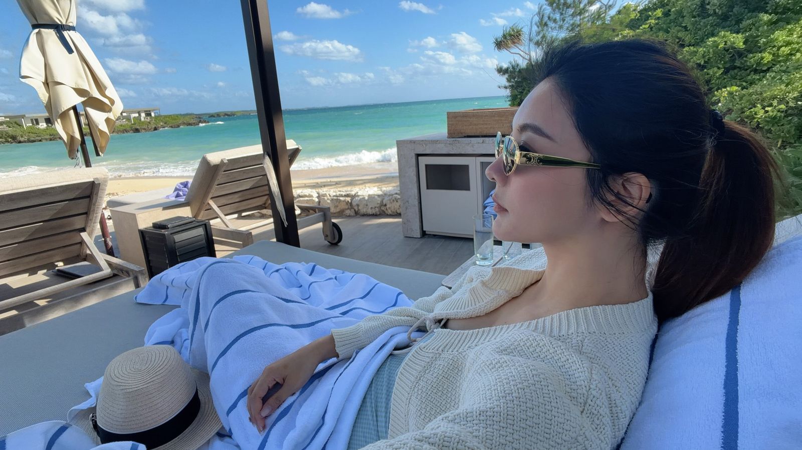 吳亞馨穿著低胸洋裝，在躺椅上享受陽光與海。（翻攝maggiewu1008 IG）