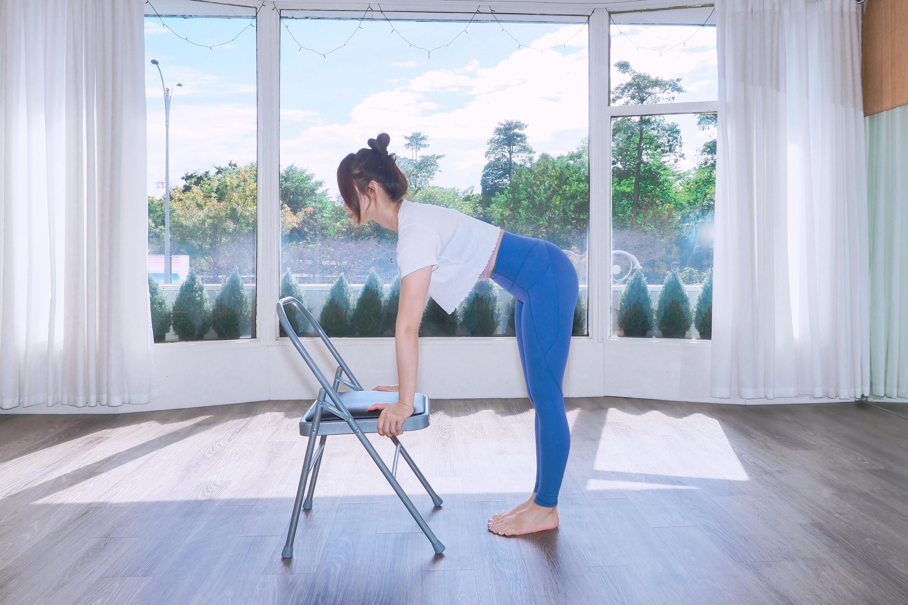 步驟1:面對椅子,雙手與肩同寬放在椅坐上,雙手掌心在肩膀正下方,雙脊椎挺直。(CHA 帶瑜去旅行提供)