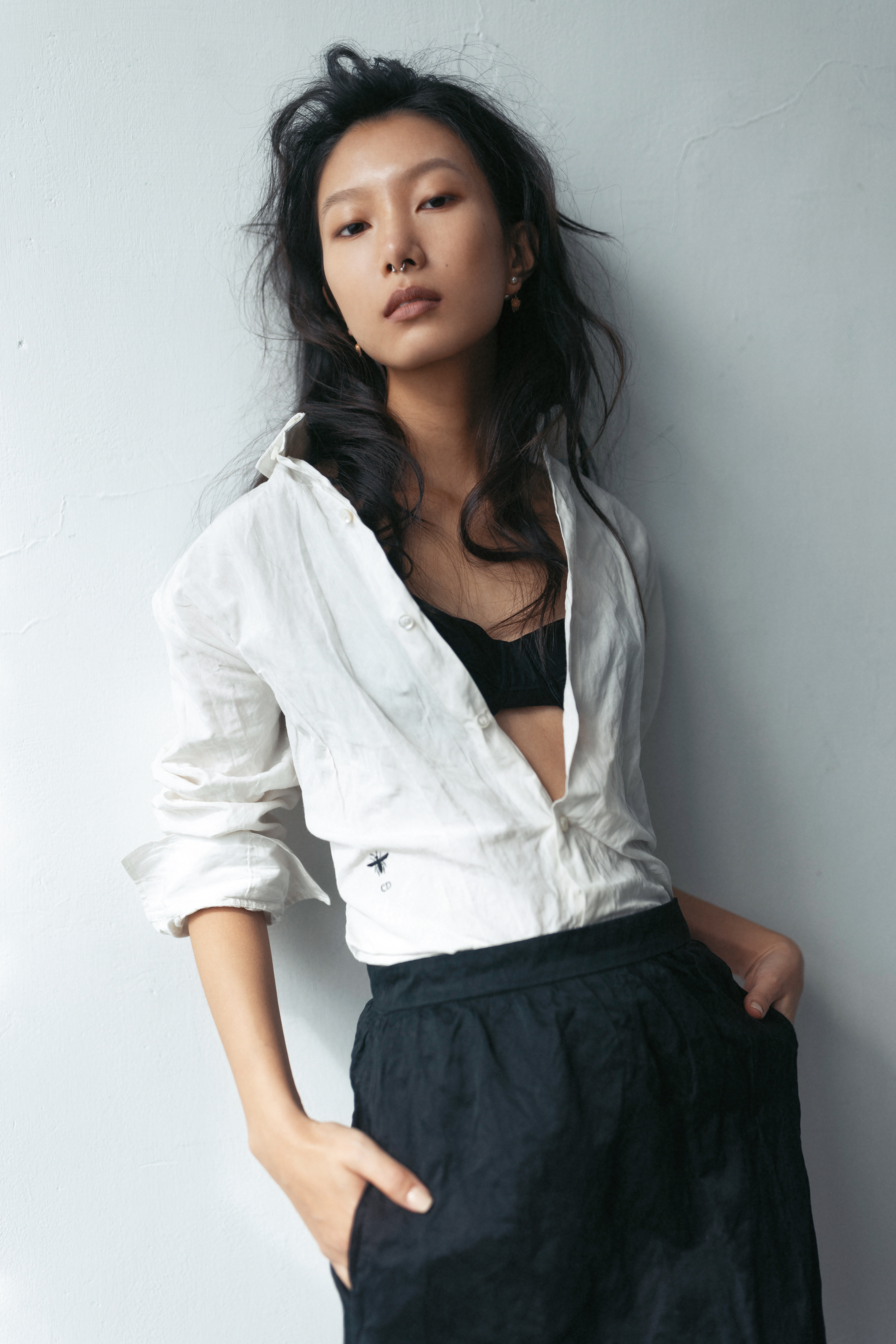 棉質白色襯衫 NT$61,000；黑色內搭bra NT$40,000；黑色過膝裙 NT$115,000；DIOR TRIBALES 粉色金屬珍珠耳環 NT$18,500  All by Dior。