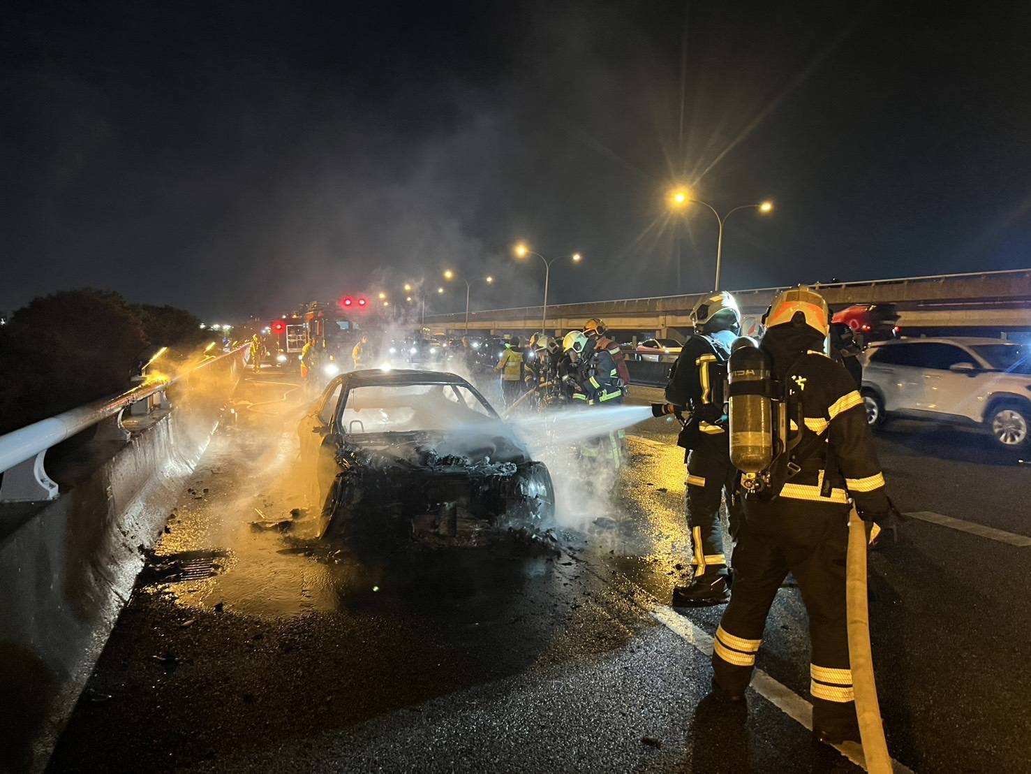 一輛轎車今晚行經國道1號汐五高架堤頂路段時突起火燃燒，整輛車陷入火海。（翻攝畫面）