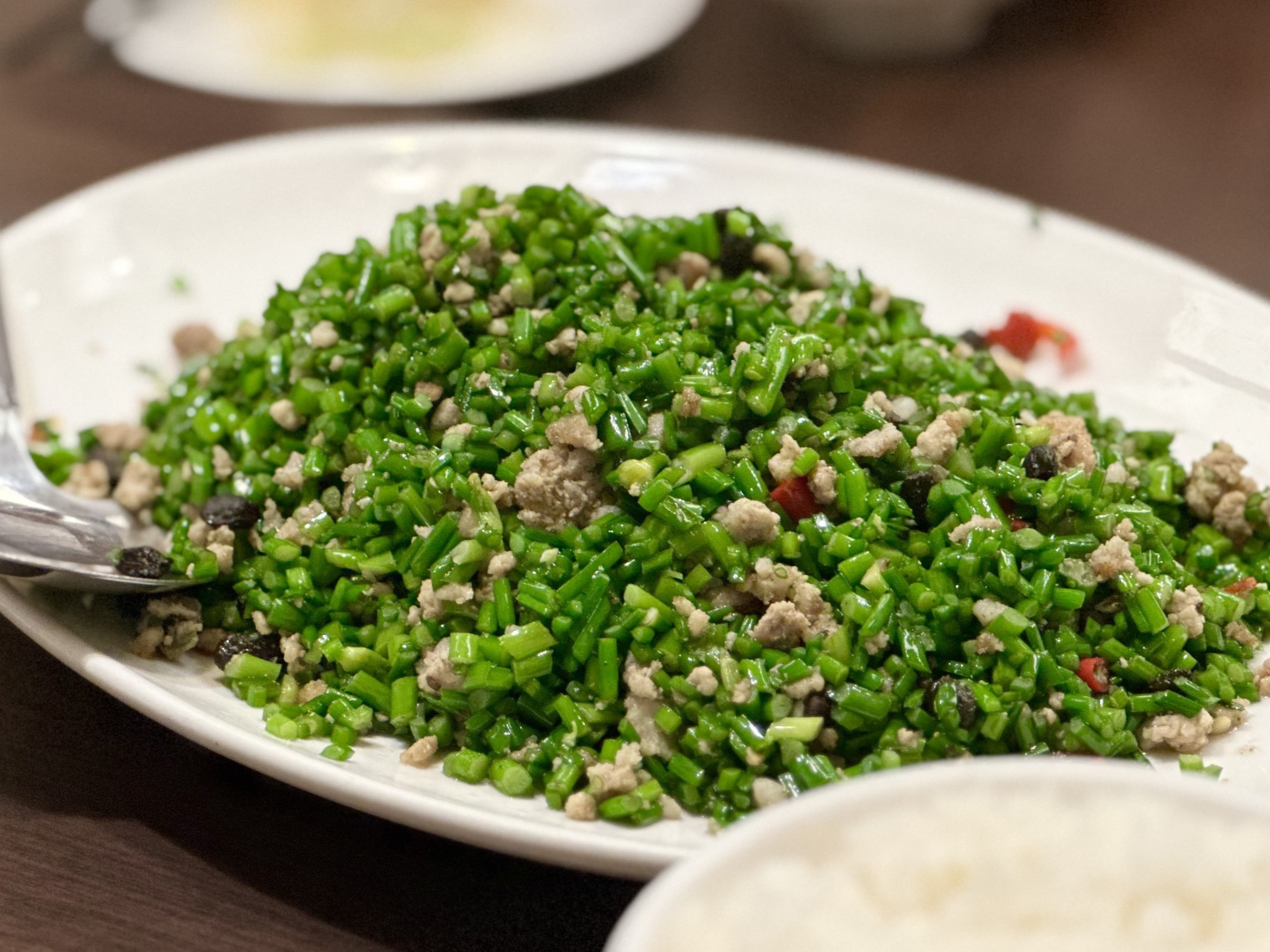 「蒼蠅頭」韭菜花口感細脆，配肉末、豆豉、辣椒一起吃，鹹香下飯。（240元／份）