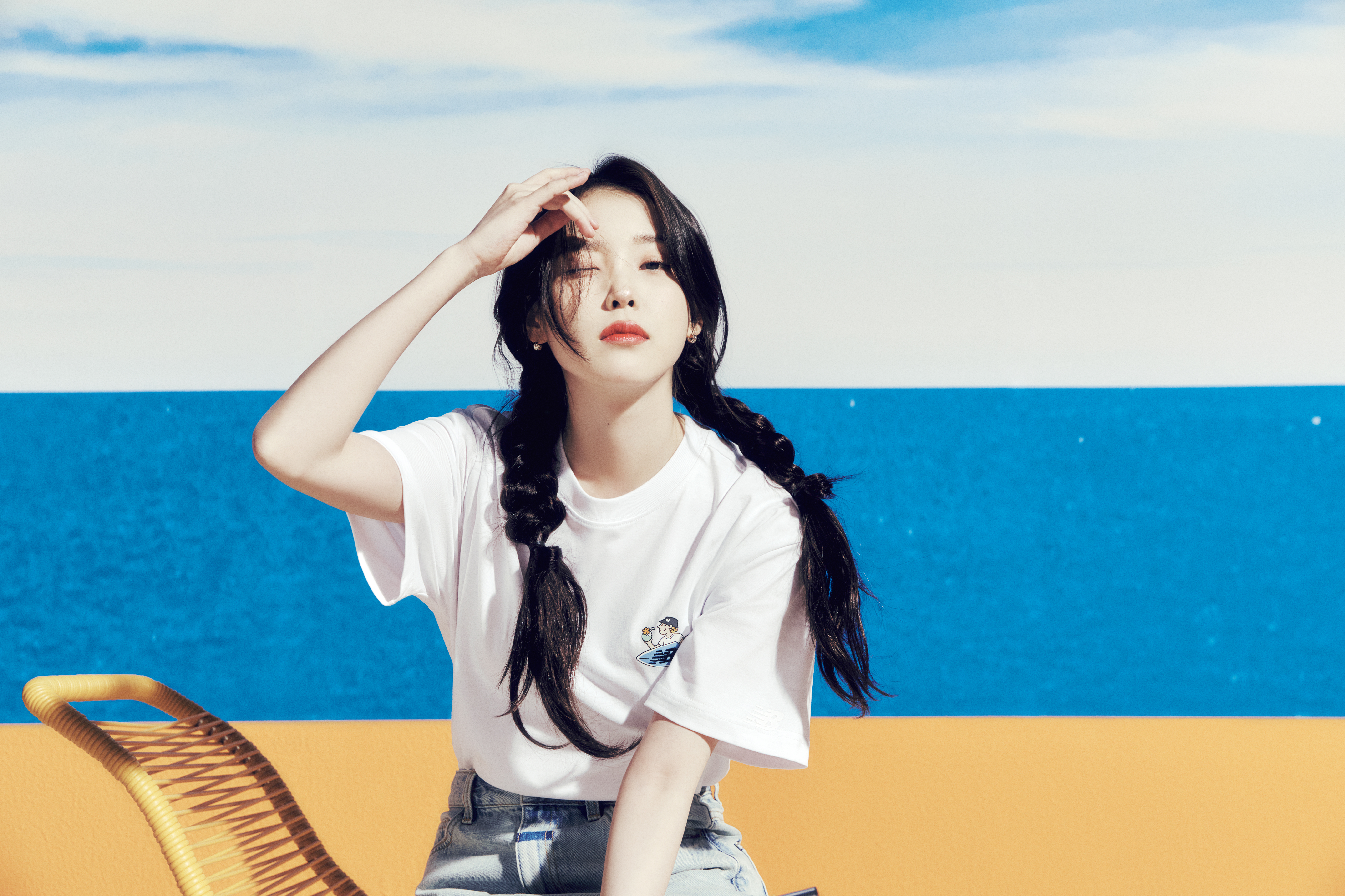 IU以白色 Q 板衝浪圖案上衣展現海邊活潑率性的夏日穿搭。SURFING T-Shirt NT$1,480(New Balance提供)
