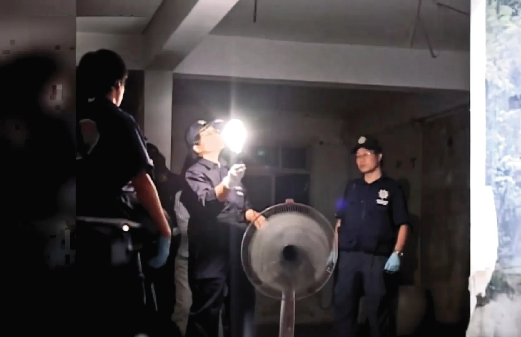 邱家老宅內部因斷電十分昏暗，警方拿手電筒邊照邊搜索。（翻攝東森新聞）