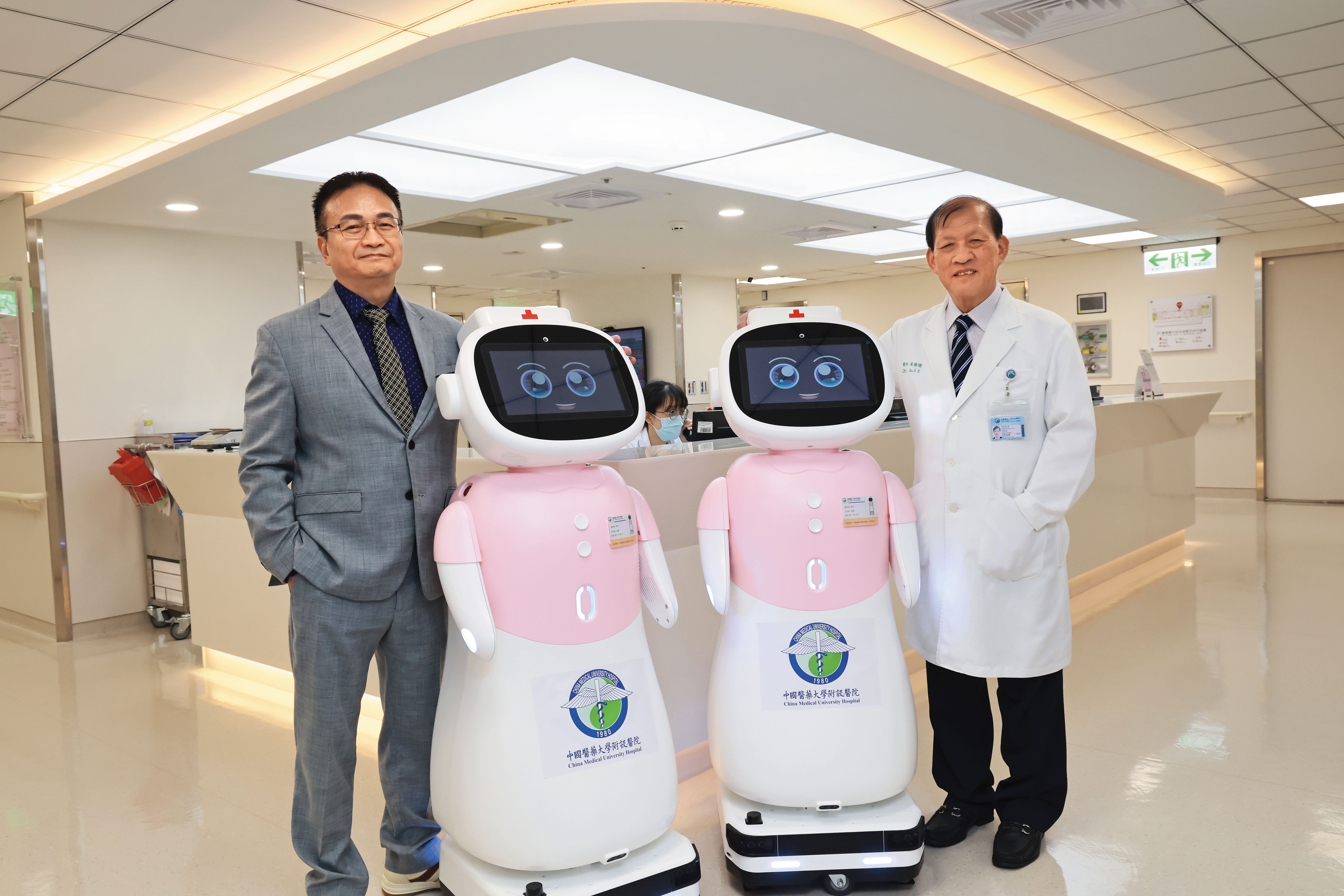 藉助中國醫藥大學暨醫療體系的資源，長聯科技迅速讓護理協作機器人愛寶，進入醫療場域「上工」。左為長聯科技董事長李友錚，右為中醫大附醫院長周德陽。