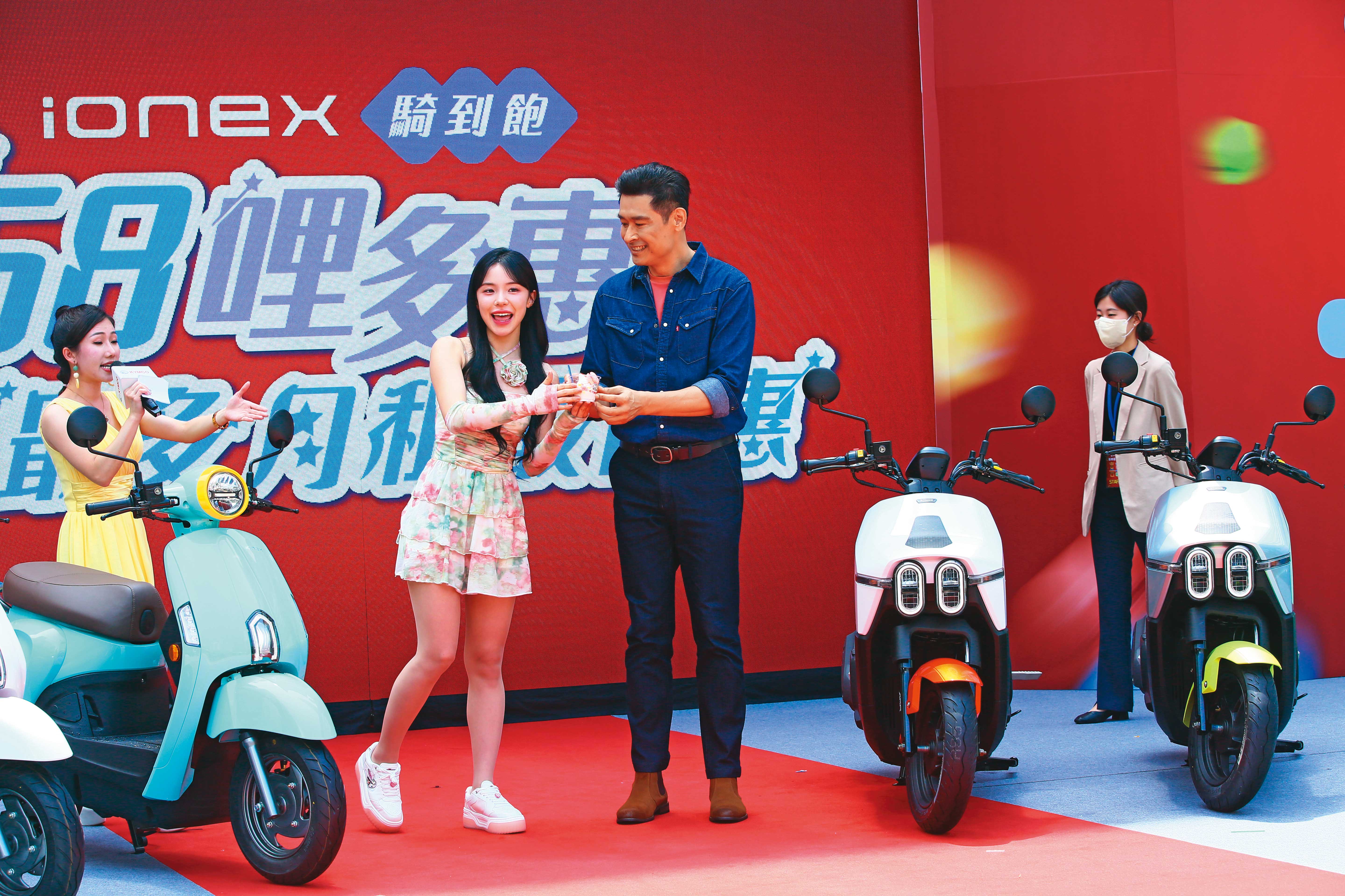 柯勝峯（右）要衝高光陽電動機車銷售量，找來啦啦隊人氣女神李多慧（中）站台炒熱話題。