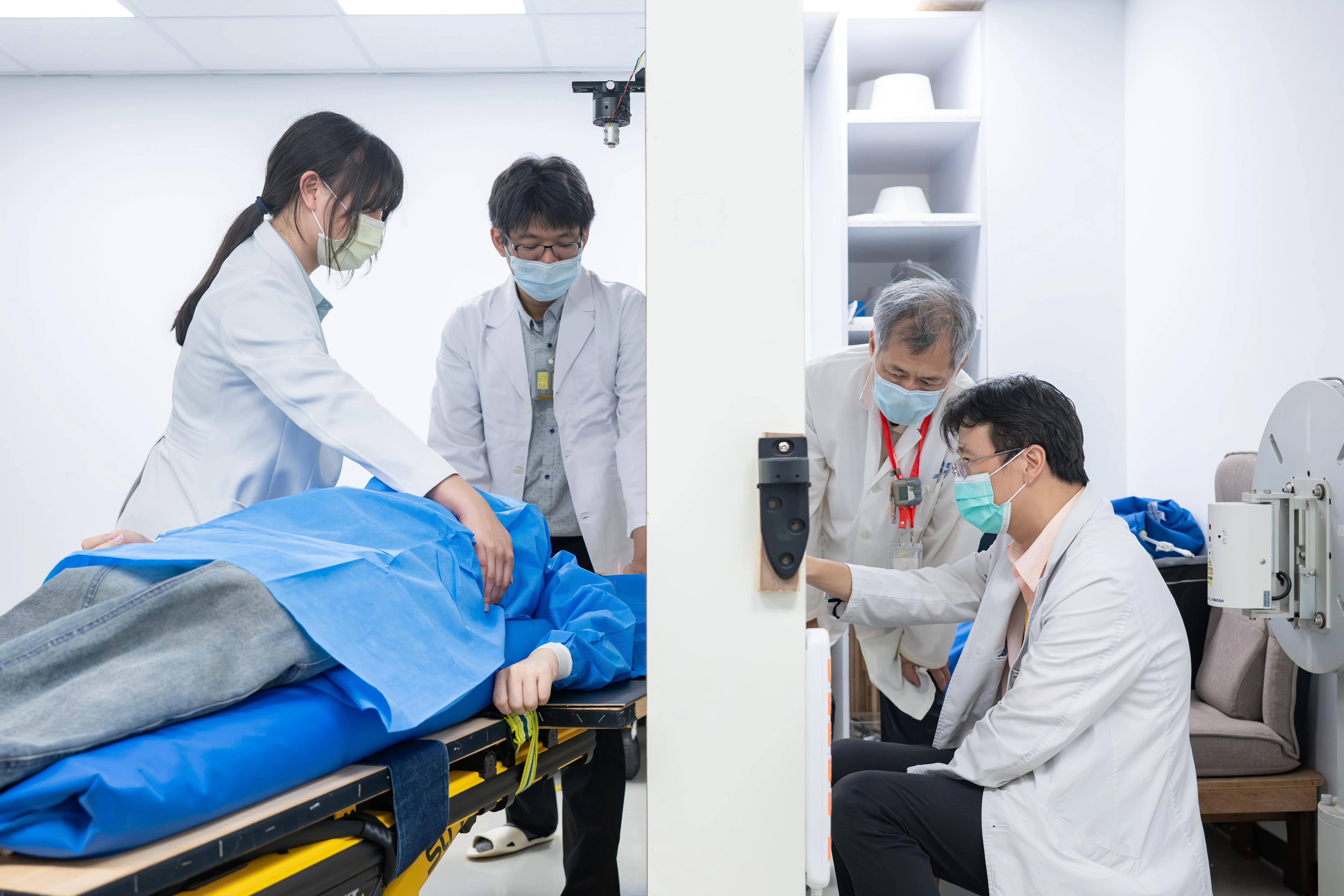 清華原科中心核能師裴晉哲（右二）、曾永信（左二）及北榮醫師陳一瑋（右一）為乳癌病患模擬中子束照射部位。（清華大學提供）