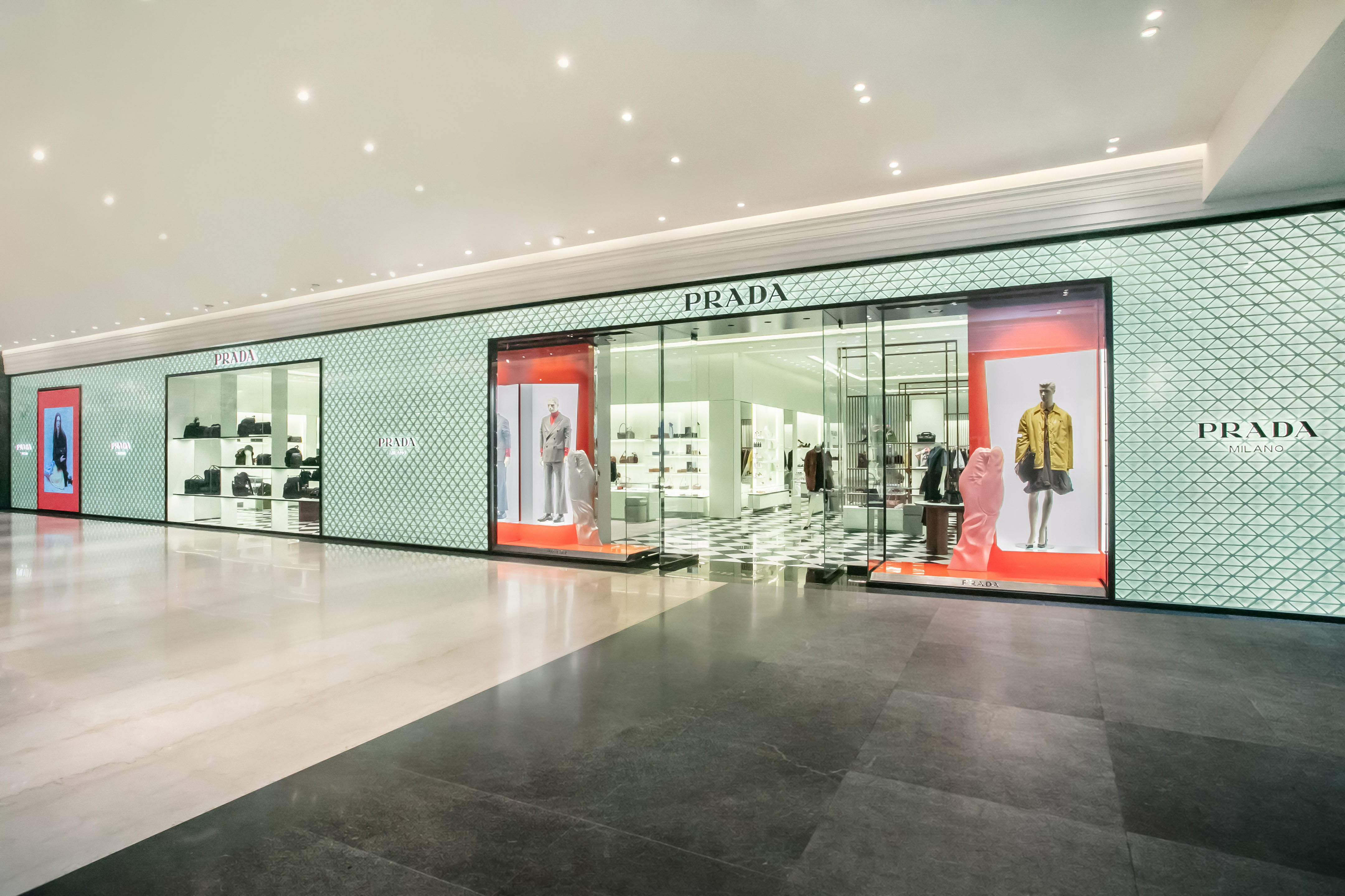 PRADA微風南山專門店外觀由經典的三角形圖騰交錯，搭配大面積透明玻璃櫥窗。（PRADA提供）