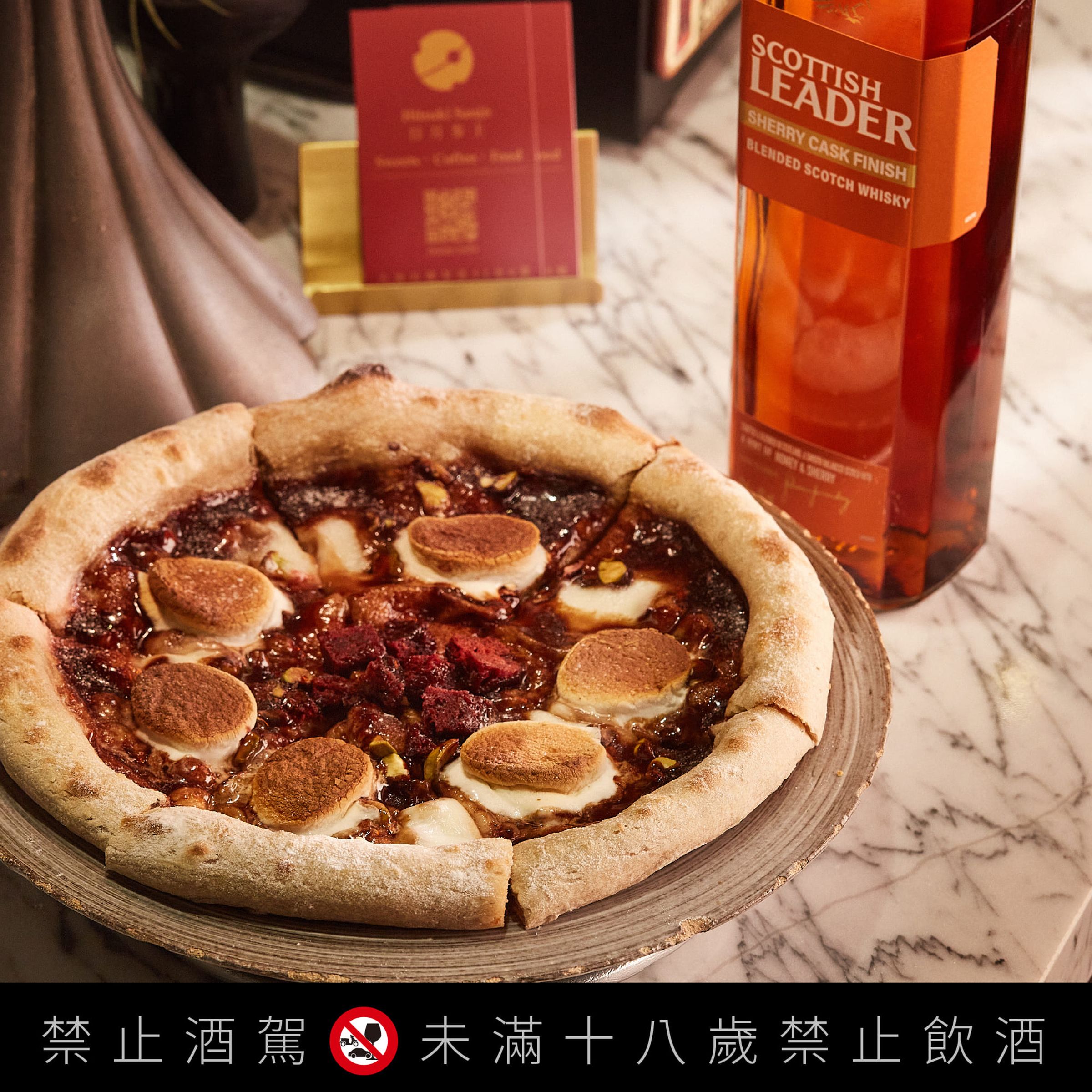 日月参上Hitsuki Sanjo的開心果巧克威士忌Pizza,在巧克力醬中添加金雪莉,搭配棉花糖、紅絲絨蛋糕與開心果粒,創造多層次滋味。(仕高利達提供)