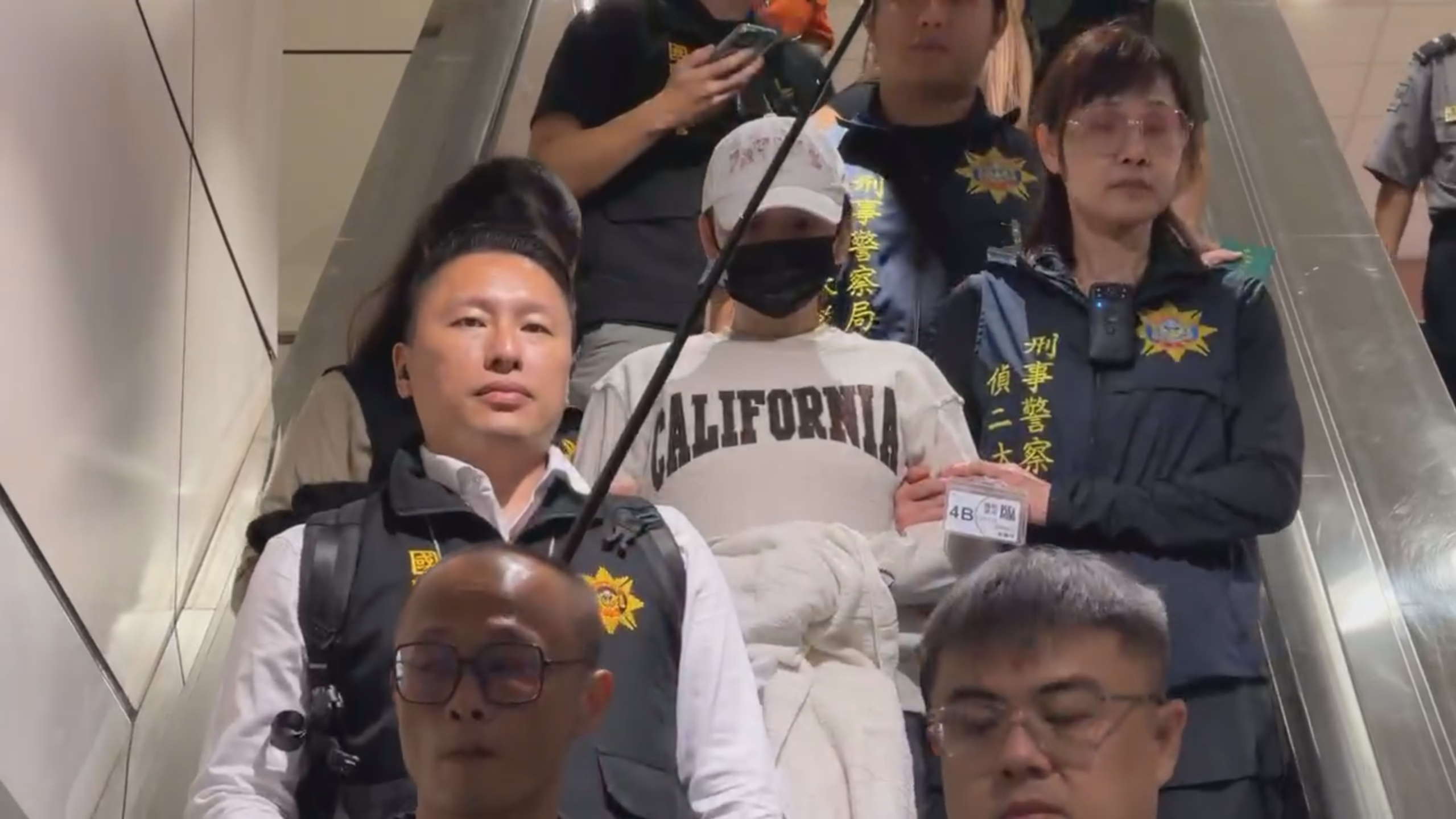 劉喬安遣返回台，遭上銬低頭不語。（鏡新聞提供）