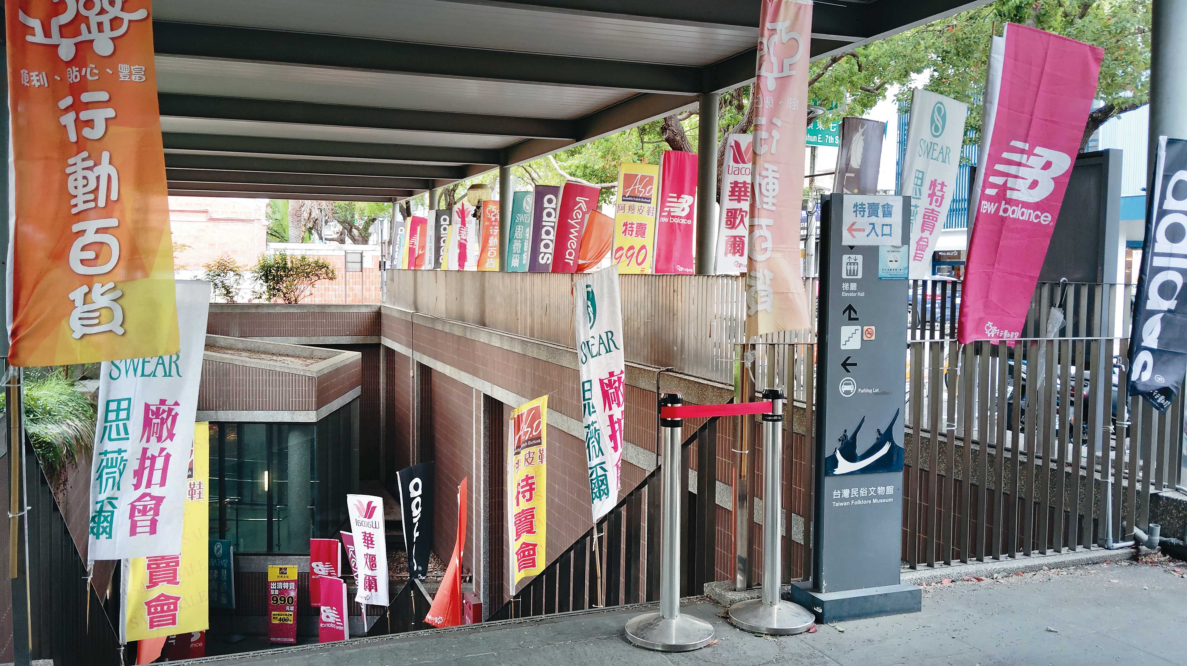 臺灣民俗文物館展區入口處插滿攤商廣告旗幟，吸引顧客上門消費。（鄧玉瑩攝）