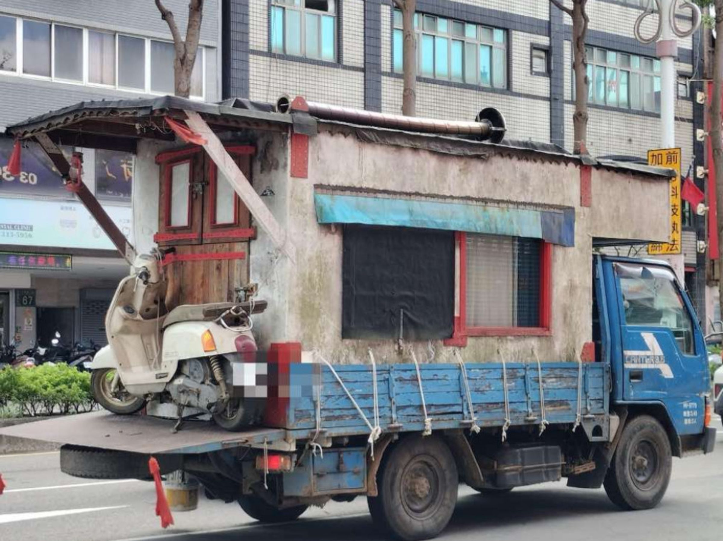 網友在路上直擊有輛貨車後車斗上竟載一座磚瓦屋,質疑這類改裝車的安全性。(翻攝爆料公社)