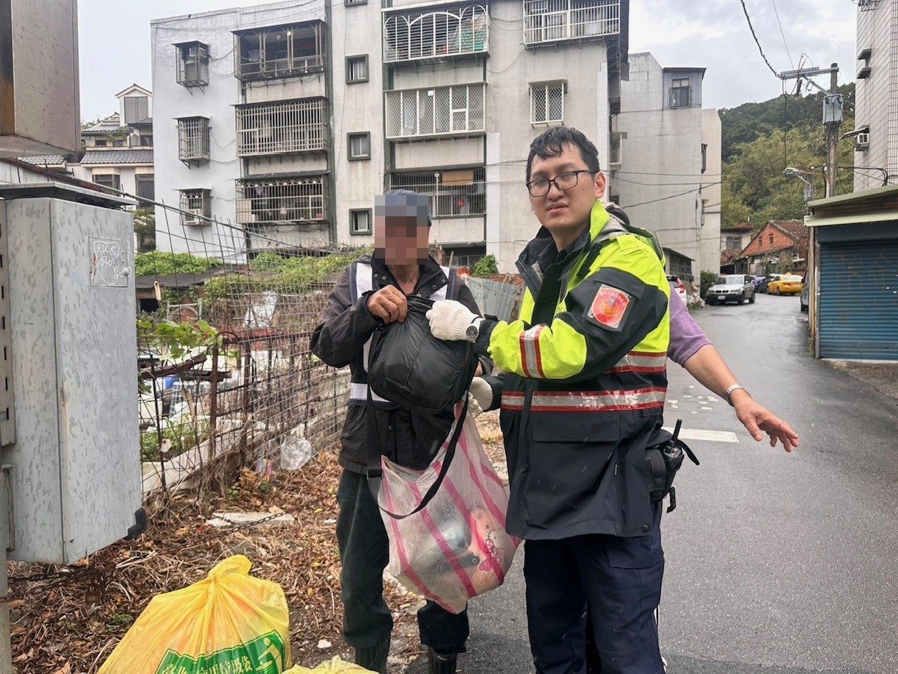 員警協助老翁翻找垃圾堆,最後成功尋獲老翁的包包。(北投分局提供)