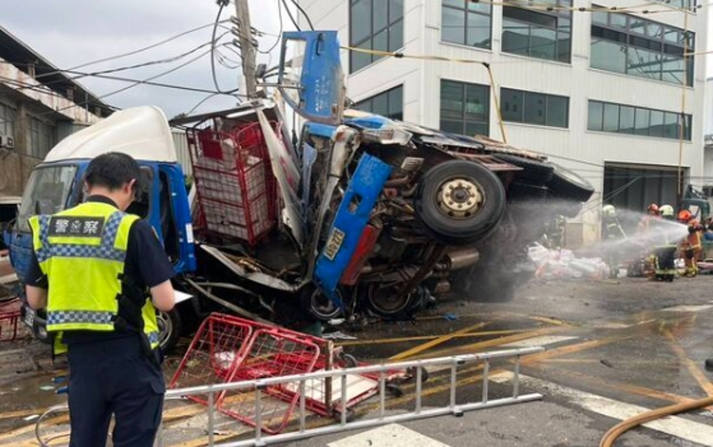 由於撞擊力道猛烈,路旁圍牆遭大貨車撞垮,波及停放在工廠內的車輛。(翻攝畫面)