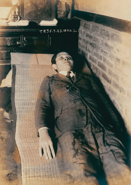 陳澄波遺照裡的張捷，蹲著扛住門板，讓攝影師拍陳澄波遺容。（財團法人陳澄波文化基金會提供）