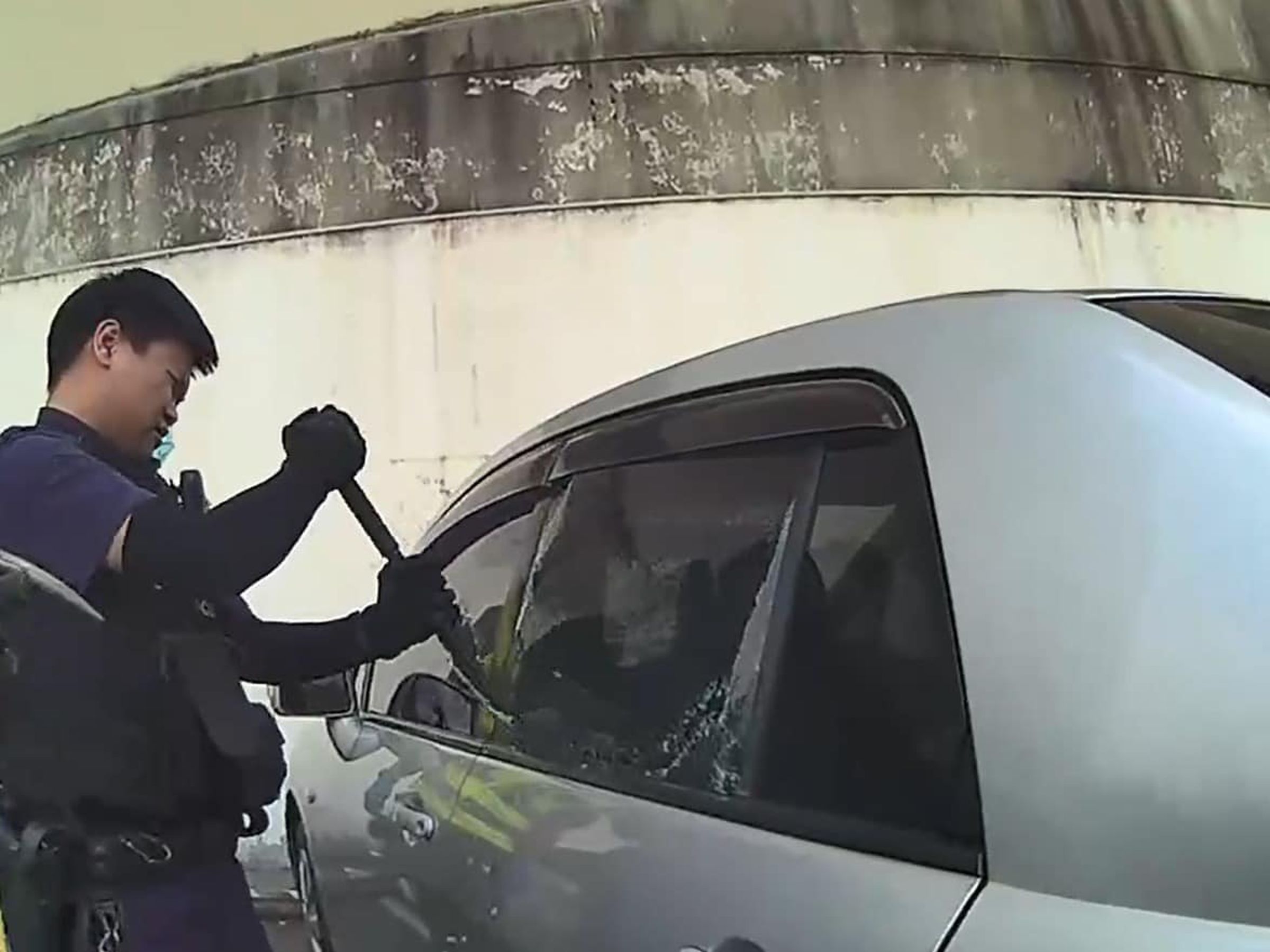 女報案稱車子自動上鎖1歲兒困車內,警方破窗救人才化解這場危機。(翻攝自桃園市政府警察局臉書)