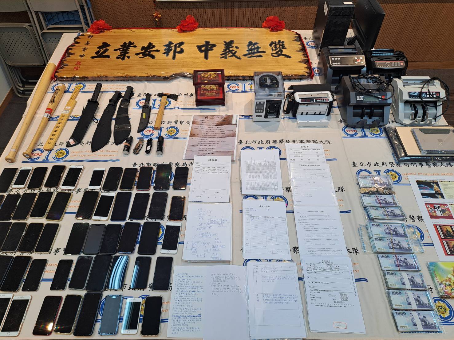 警方現場查扣現金74萬餘元、點鈔機、土地及建物謄本、行動電話等犯罪證物。（翻攝畫面）