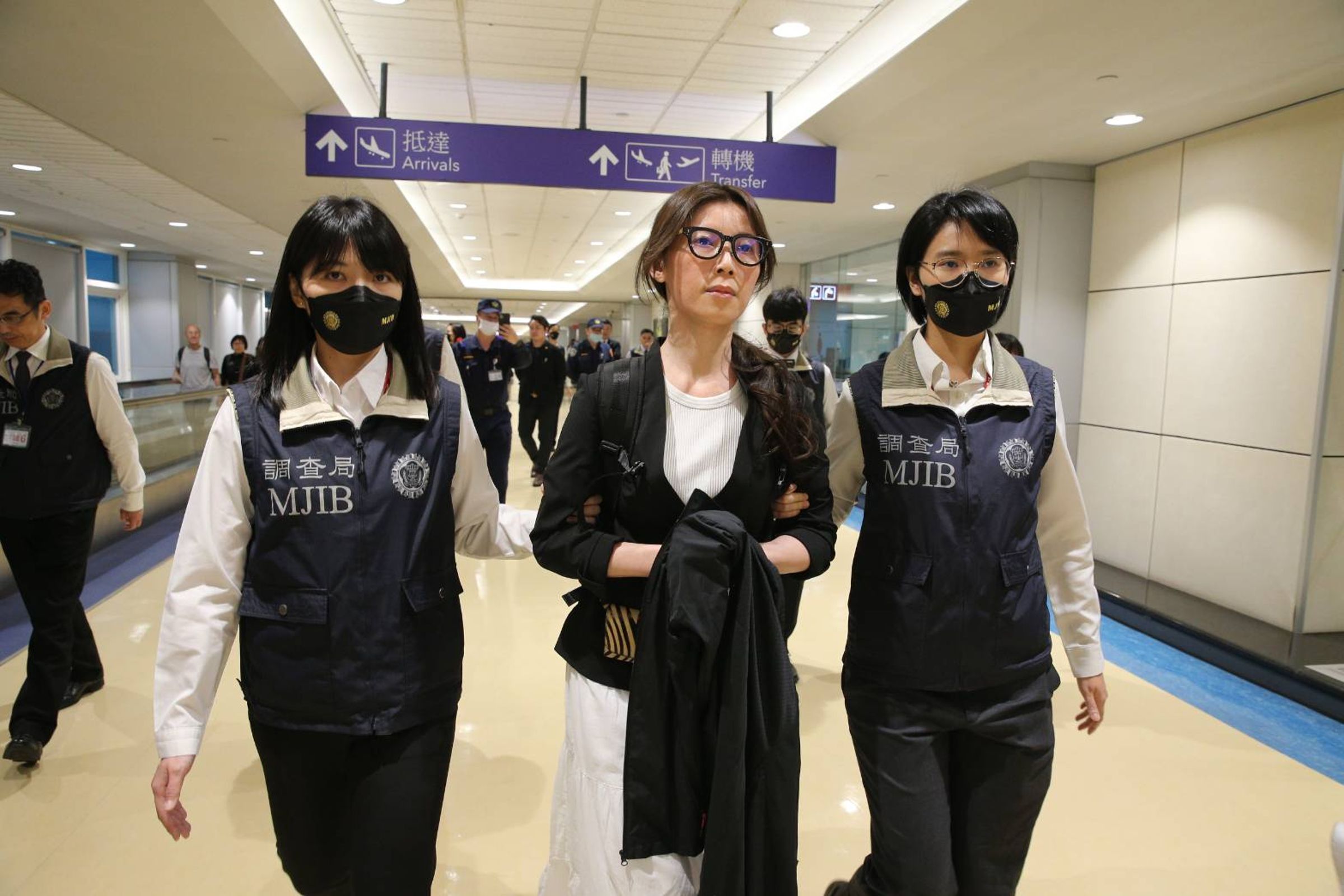 經簡單確認後,貴婦奈奈被調查局人員帶往北檢。(桃園機場記者聯誼會提供)(桃園機場記者聯誼會提供)