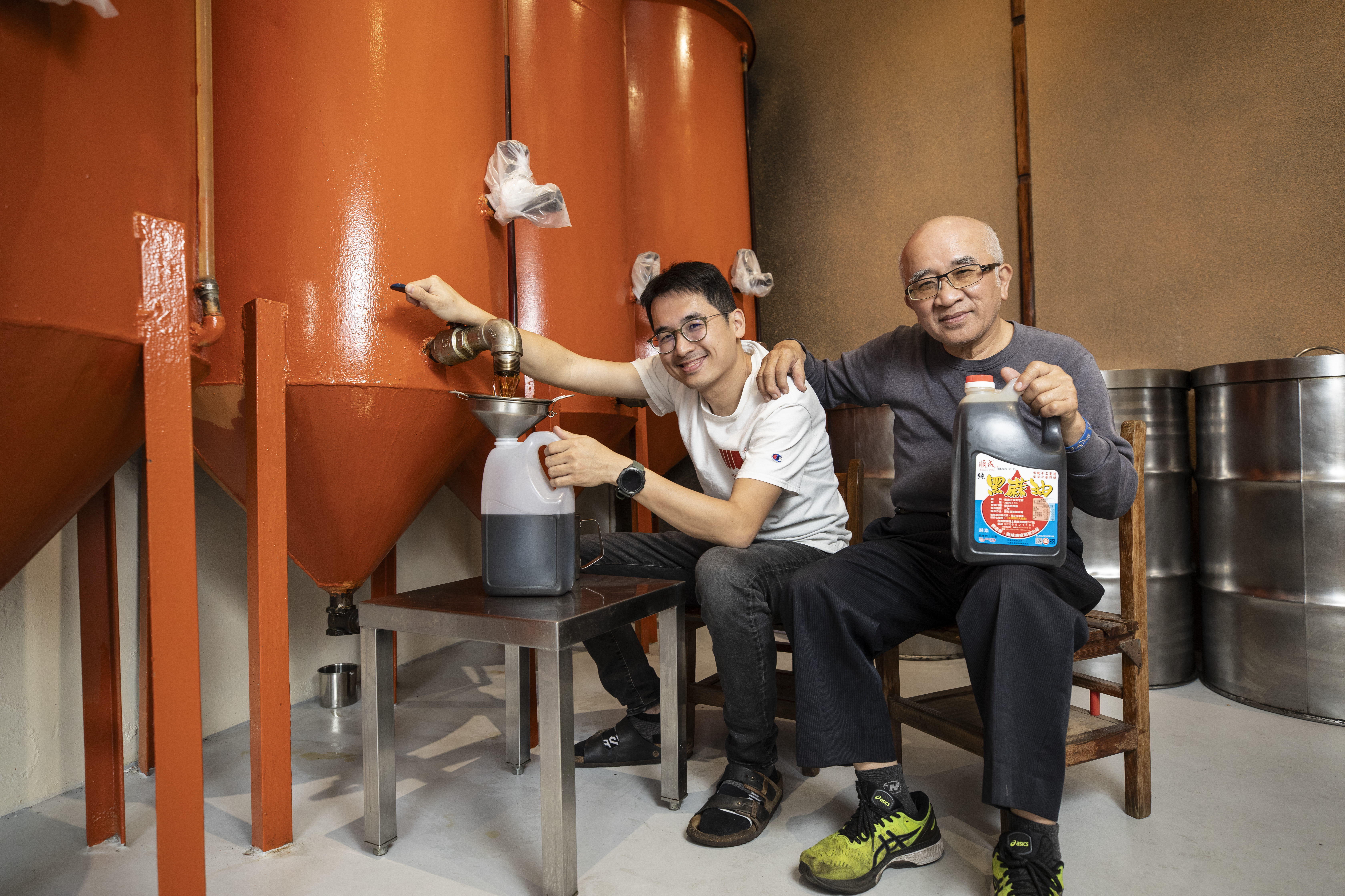 第三代王偉盛（左）返家與父親王德煙（右）一起做麻油，改善設備也帶進行銷觀念，讓老廠從沒沒無名成為雲林知名伴手禮之一。
