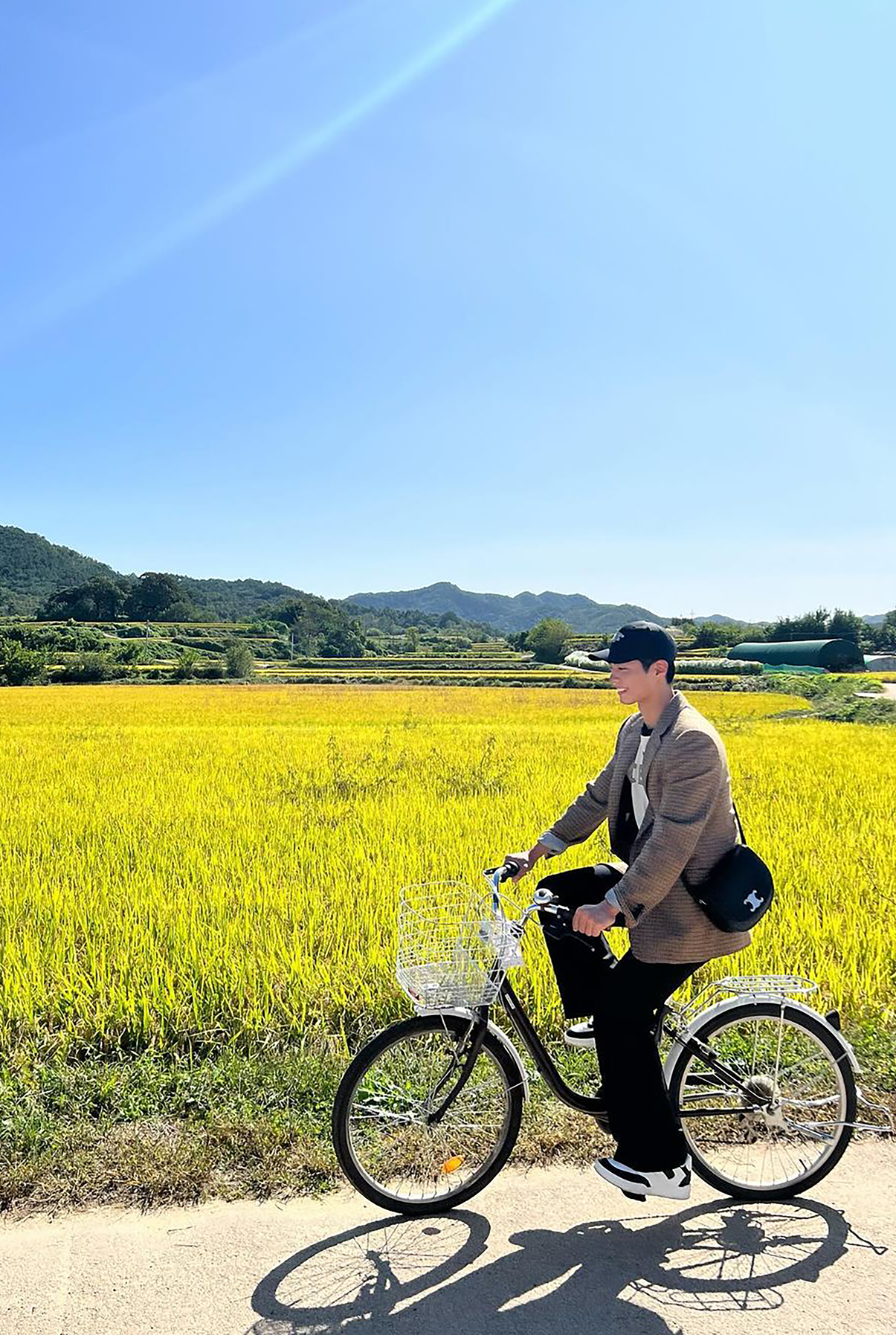 朴寶劍以千鳥格紋經典西裝外套搭配BESACE TRIOMPHE手袋，一系列「秋日男友風」旅照展現清新大男孩氣質。（CELINE提供）