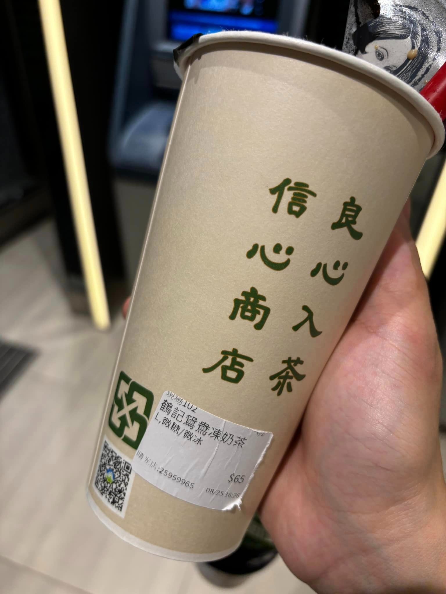消費者在鶴茶樓飲料裡吃到爆漿蟑螂，對比杯身「信心商店，良心入茶」的標語格外諷刺。（翻攝自爆料公社）