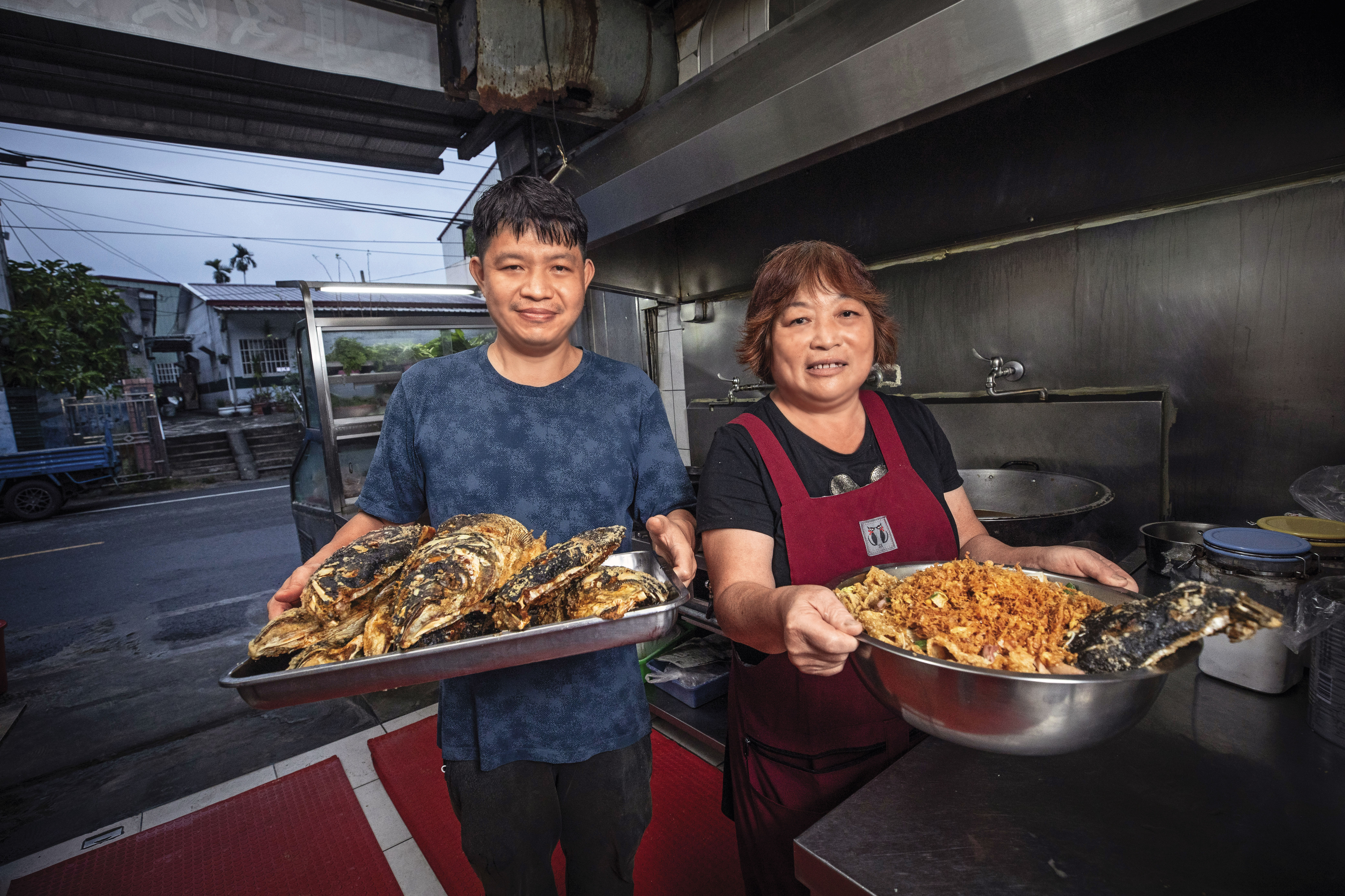 佳香餐飲部以大臉盆砂鍋魚頭闖出名號,開業近30年,老闆娘江明苓(右)仍站第一線發號施令,長子江俊毅(左)在她調教下已能擔綱掌廚,分擔許多工作。