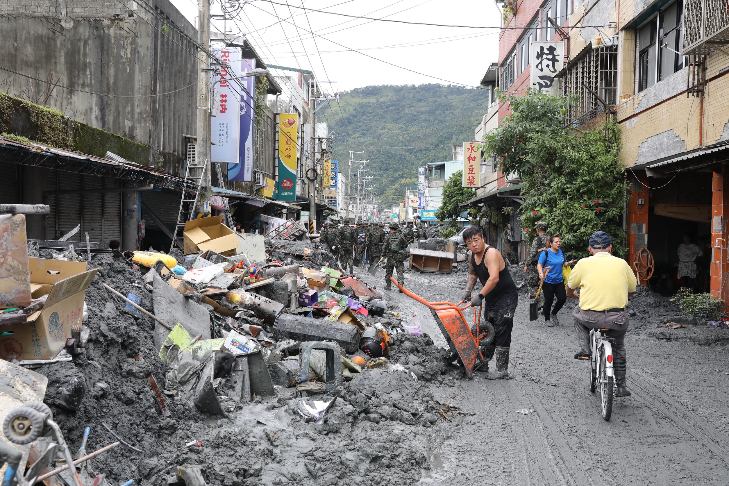 花蓮縣光復鄉街道仍有大量淤泥待清理，居民、國軍與志工齊心協力清理。