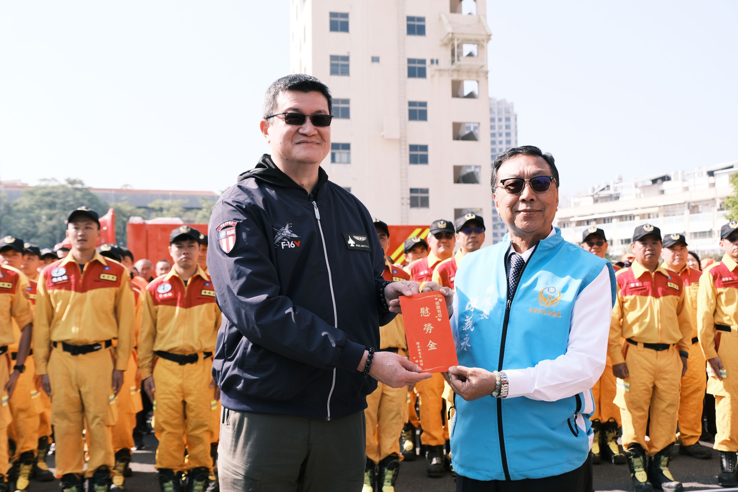 馬士元（左）頒贈慰勞金予高雄市義消總隊長陳義永。（消防署提供）