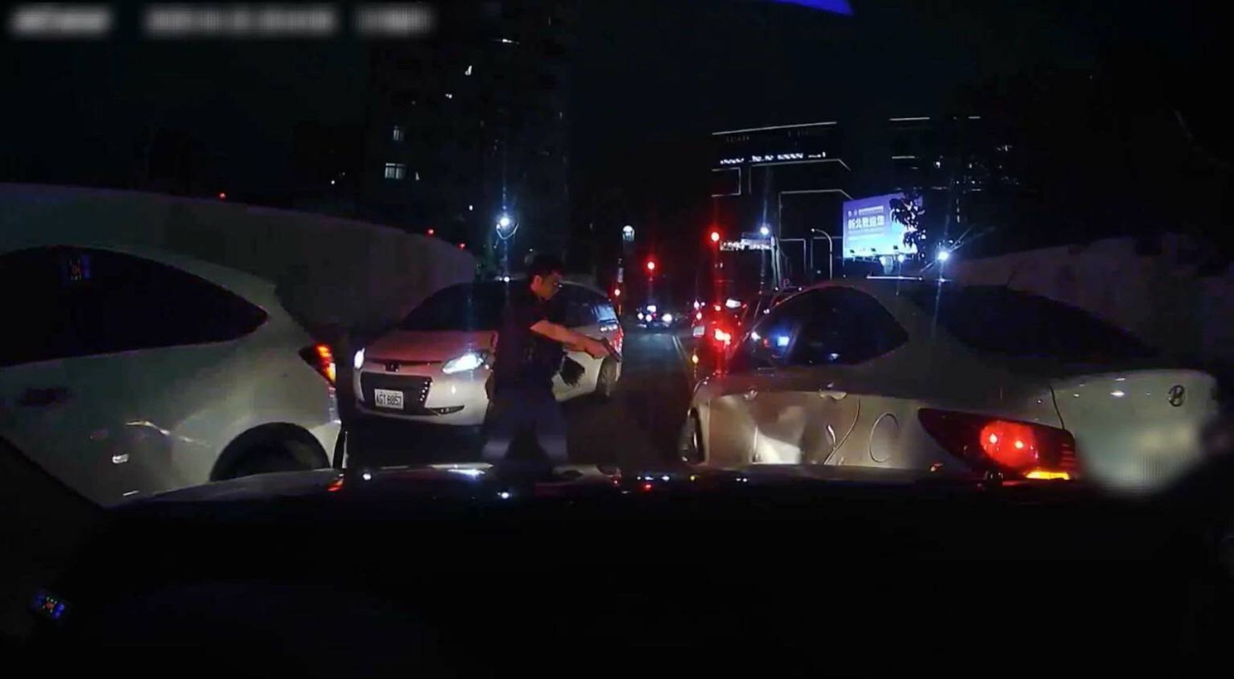 徐男因被前方停等紅燈的車輛擋住去路，竟倒車衝撞尾隨警車。（翻攝畫面）