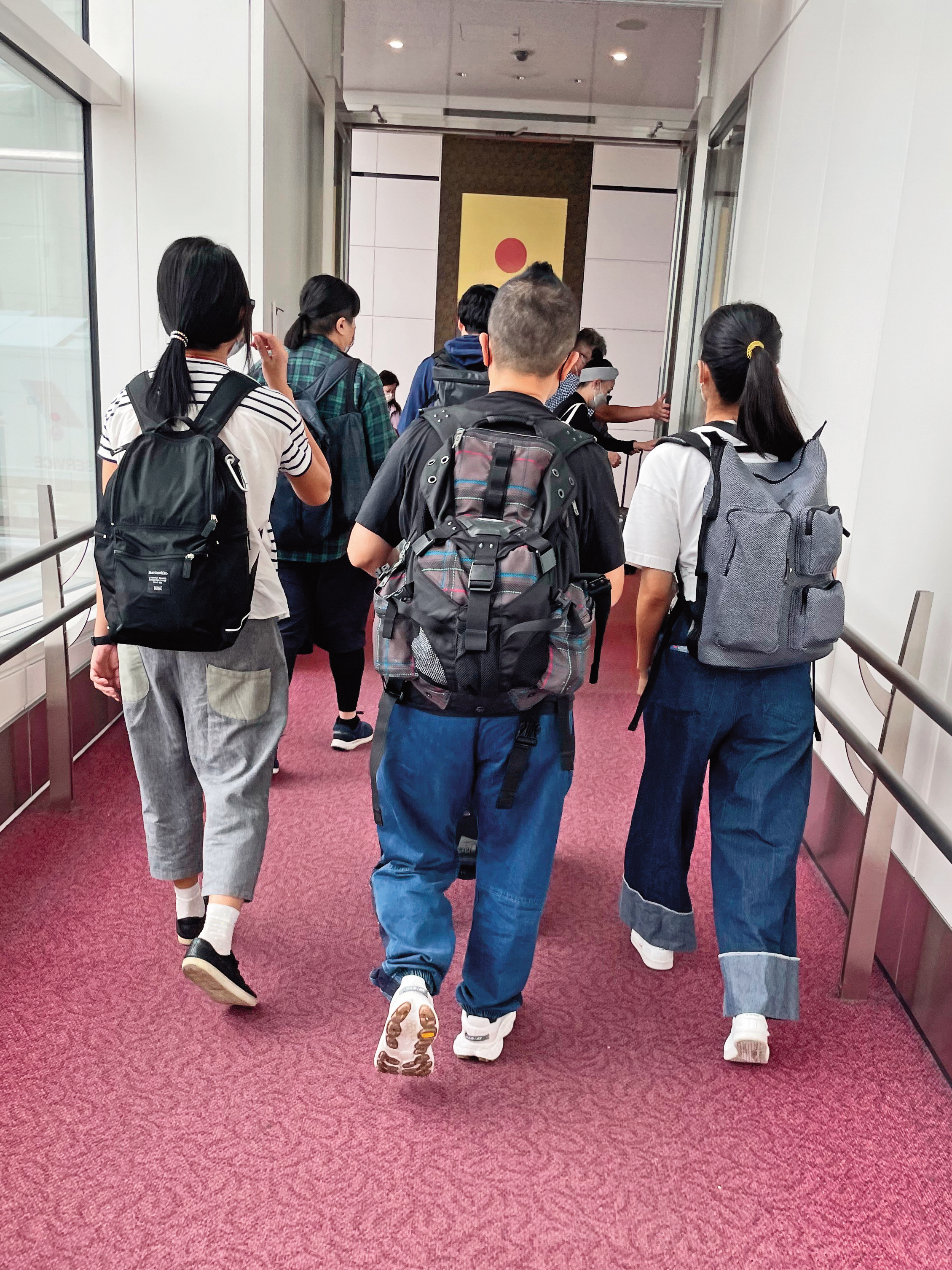 九把刀帶著妻小前往東京，搭乘的航班抵達羽田機場，下機後一家人走在廊道上。（讀者提供）