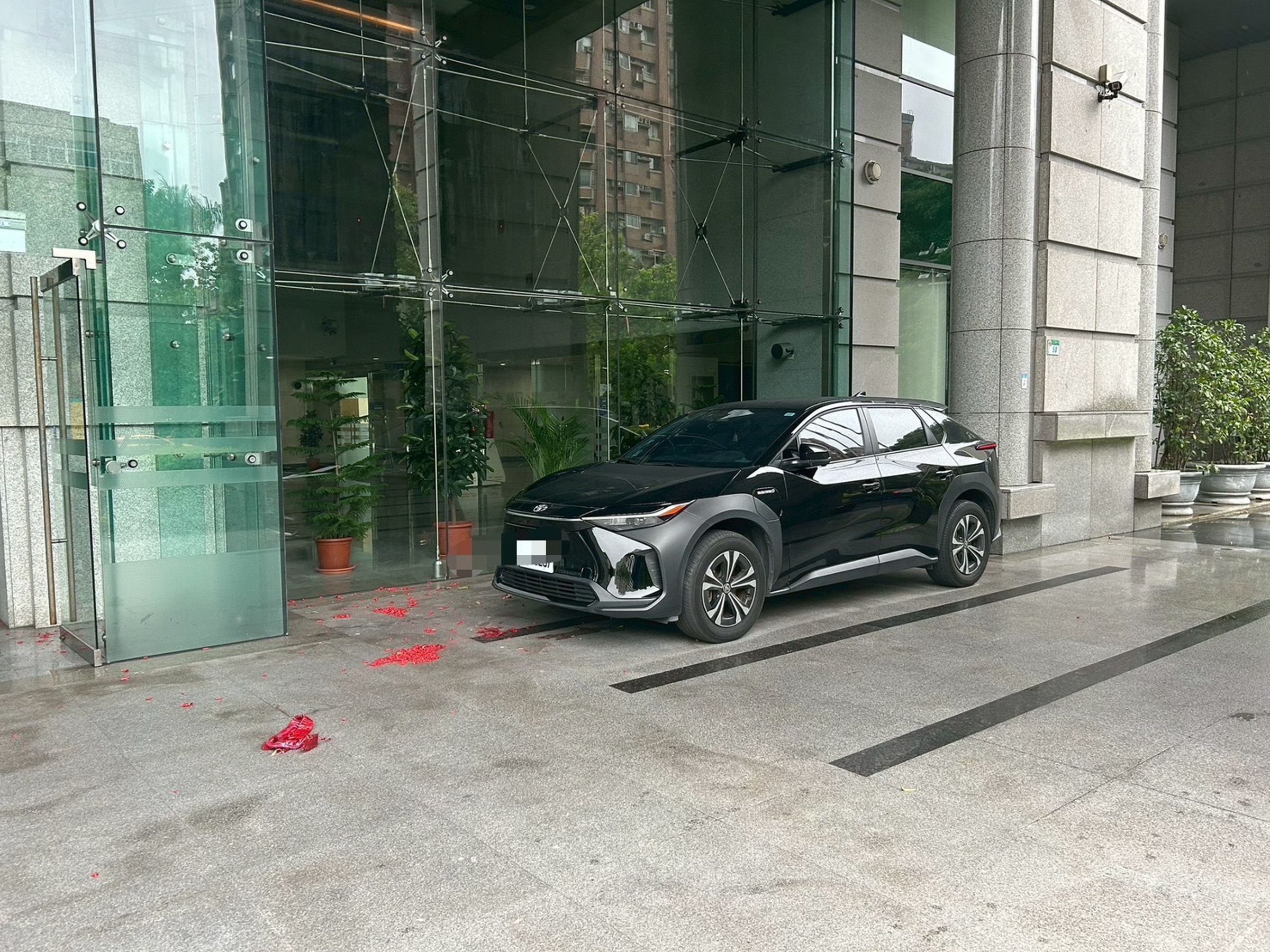 交通部門口遺留大量鞭炮紙屑，一旁車輛險遭波及。（翻攝畫面）