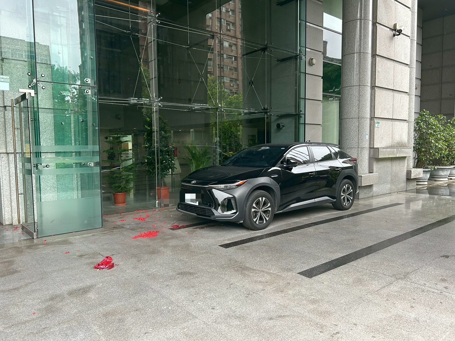 交通部門口遺留大量鞭炮紙屑，一旁車輛險遭波及。（翻攝畫面）