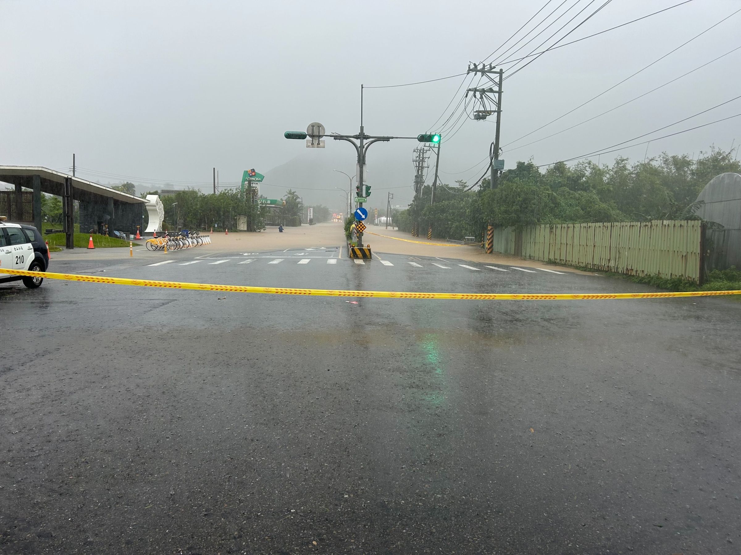 新北市往金山、萬里路段因溪水暴漲,黃色的泥水淹至馬路。(取自新北市石門區公所臉書)