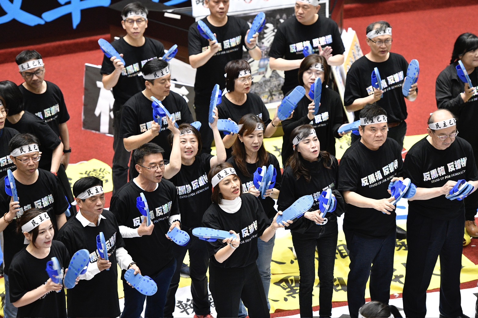 民進黨立委下午改走較溫和的方式抗爭，紛紛拿出「藍白拖」揶揄藍白兩黨。