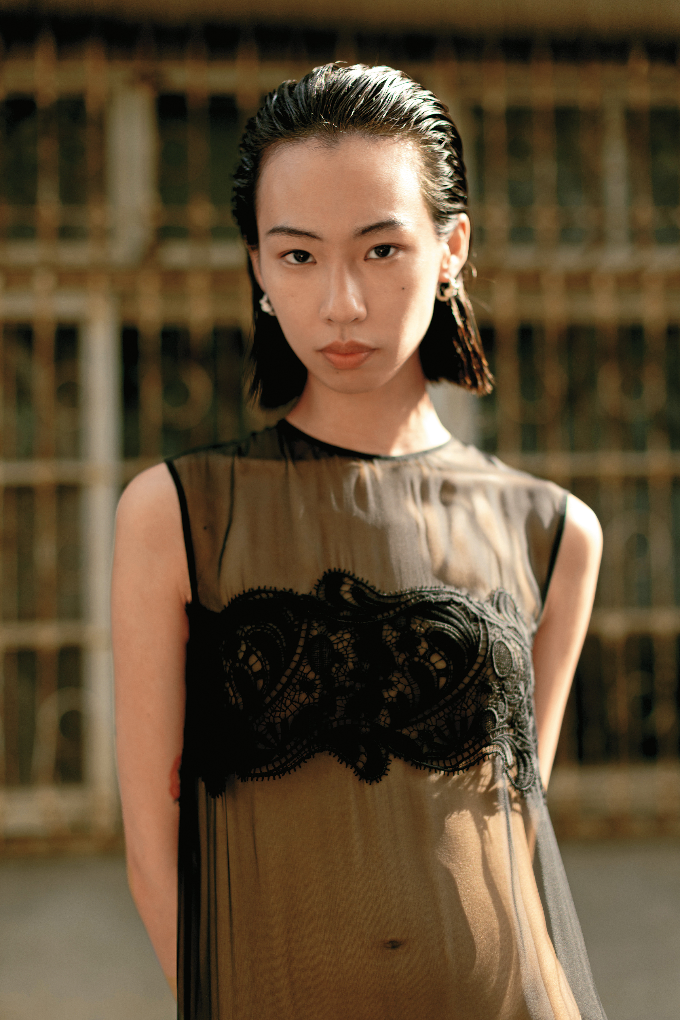黑色蕾絲透膚洋裝 NT$145,000 by FERRAGAMO、KNOT銀色飾面水晶圈形耳環 NT$26,000 by CELINE