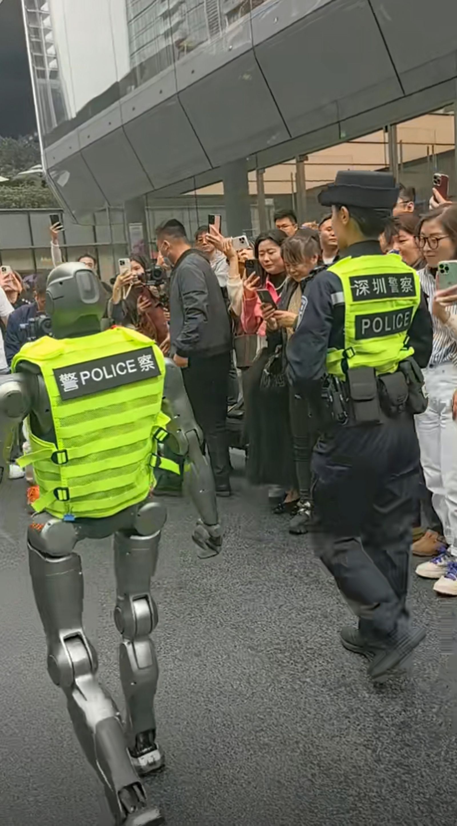 「機器人警察」穿警用背心上街,引發民眾圍觀。(翻攝抖音)