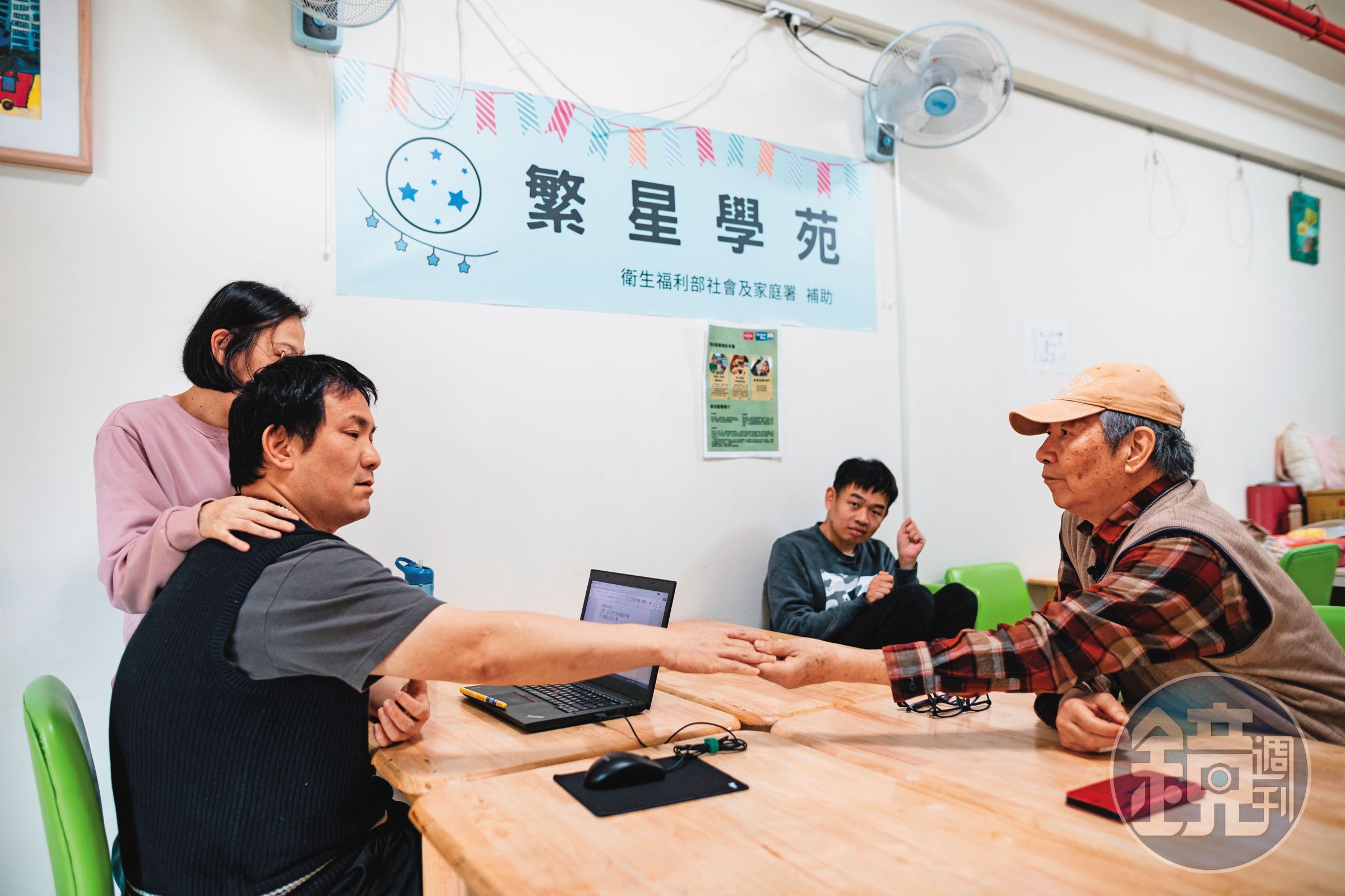 「繁星學院」裡,鄭文正(前右)的兒子(前左)在女老師扶著肩膀下,試著打字溝通。