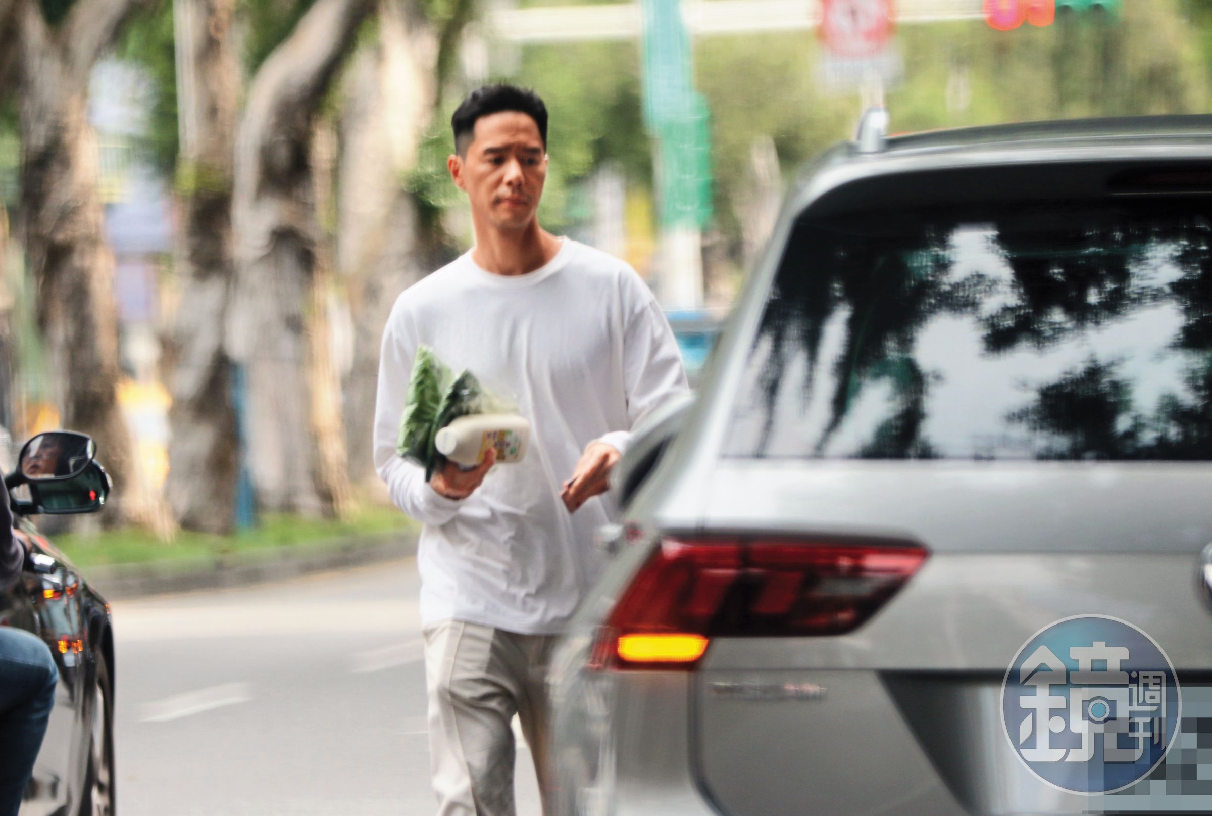 丁春誠一手抓了兩包菜和一瓶豆漿後，就驅車離開回到台北關渡某個社區。