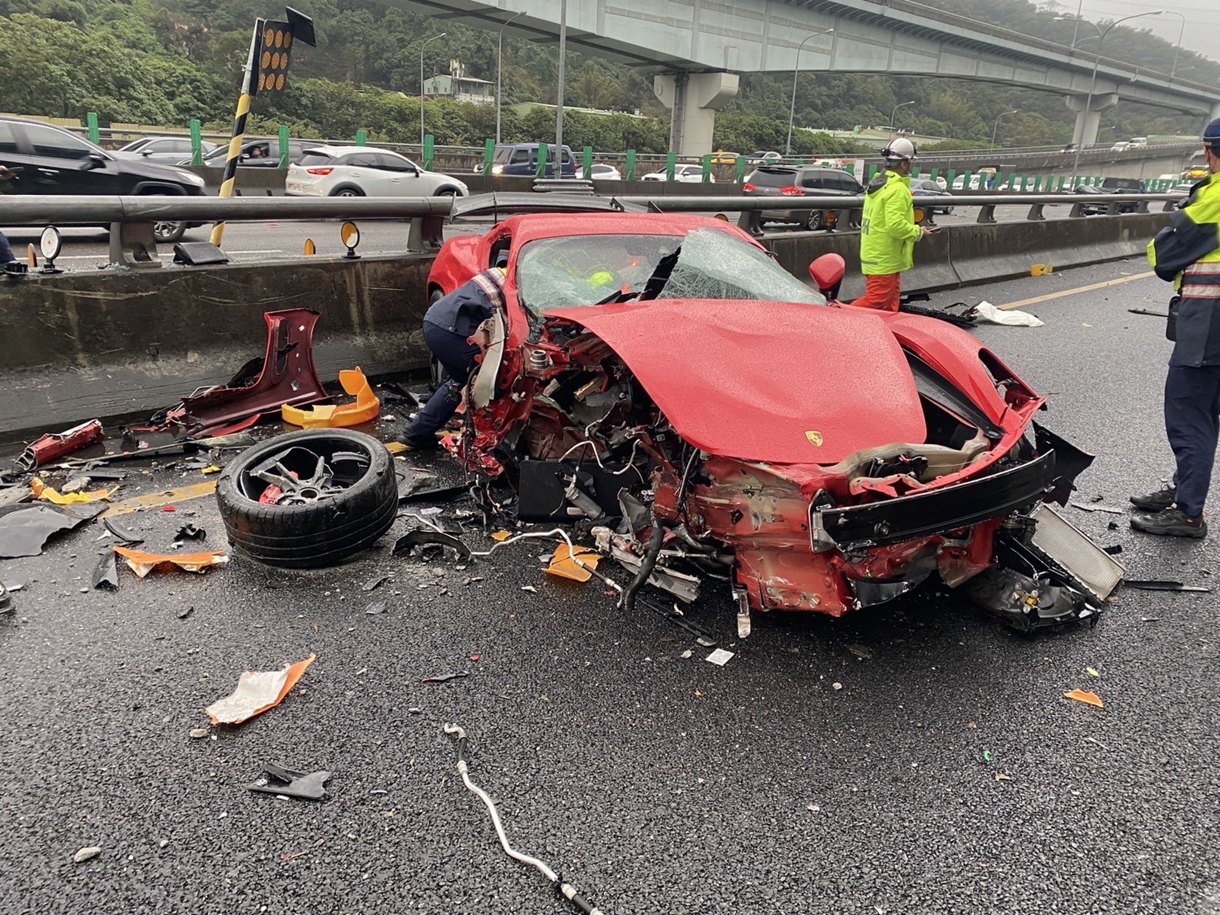 梁男駕駛保時捷自撞分隔島，導致自己被拋出車外，車輛幾乎全毀。（翻攝畫面）