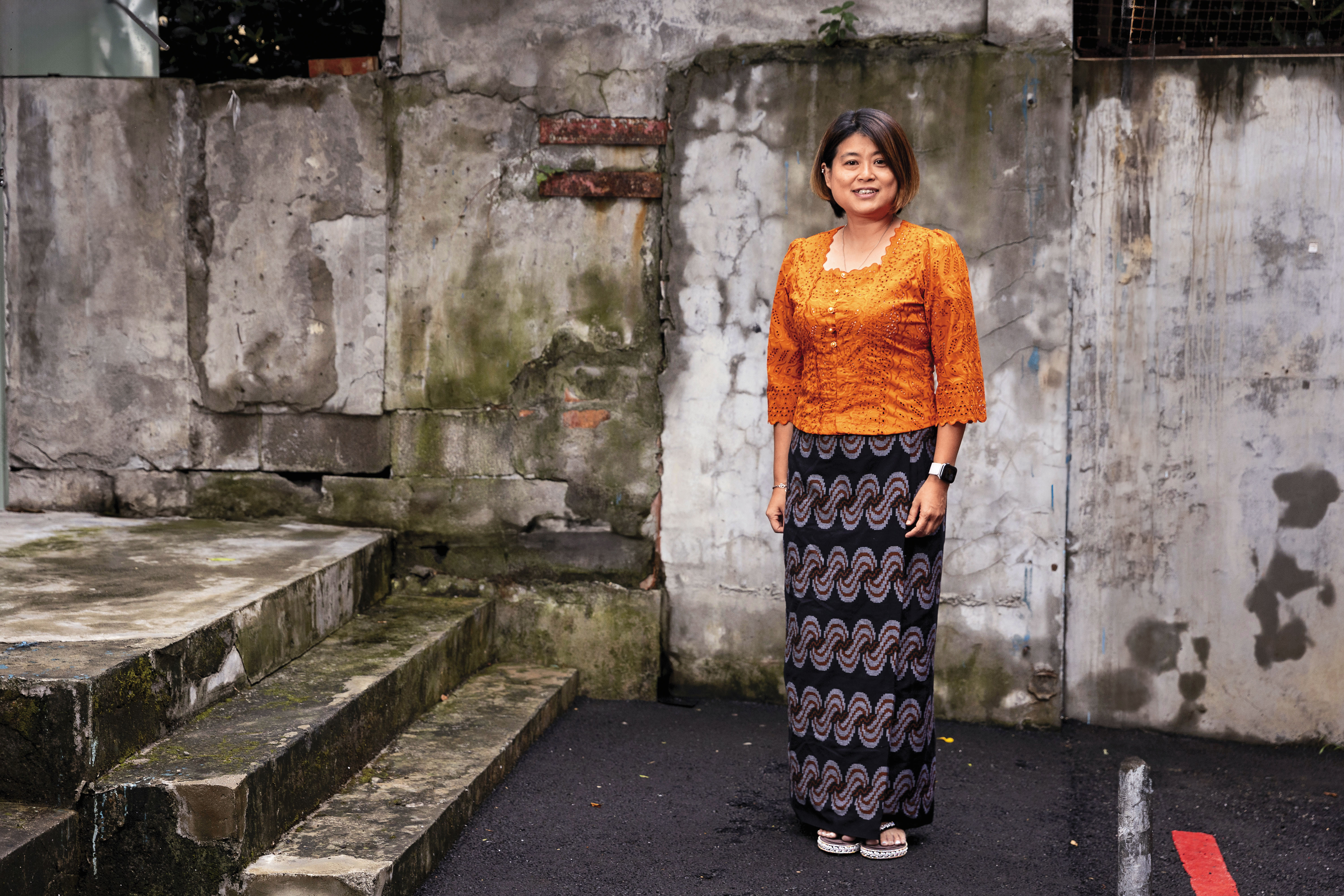 楊萬利身著緬甸婦女親手縫製的上衣，下半身是緬甸筒裙「籠基」。