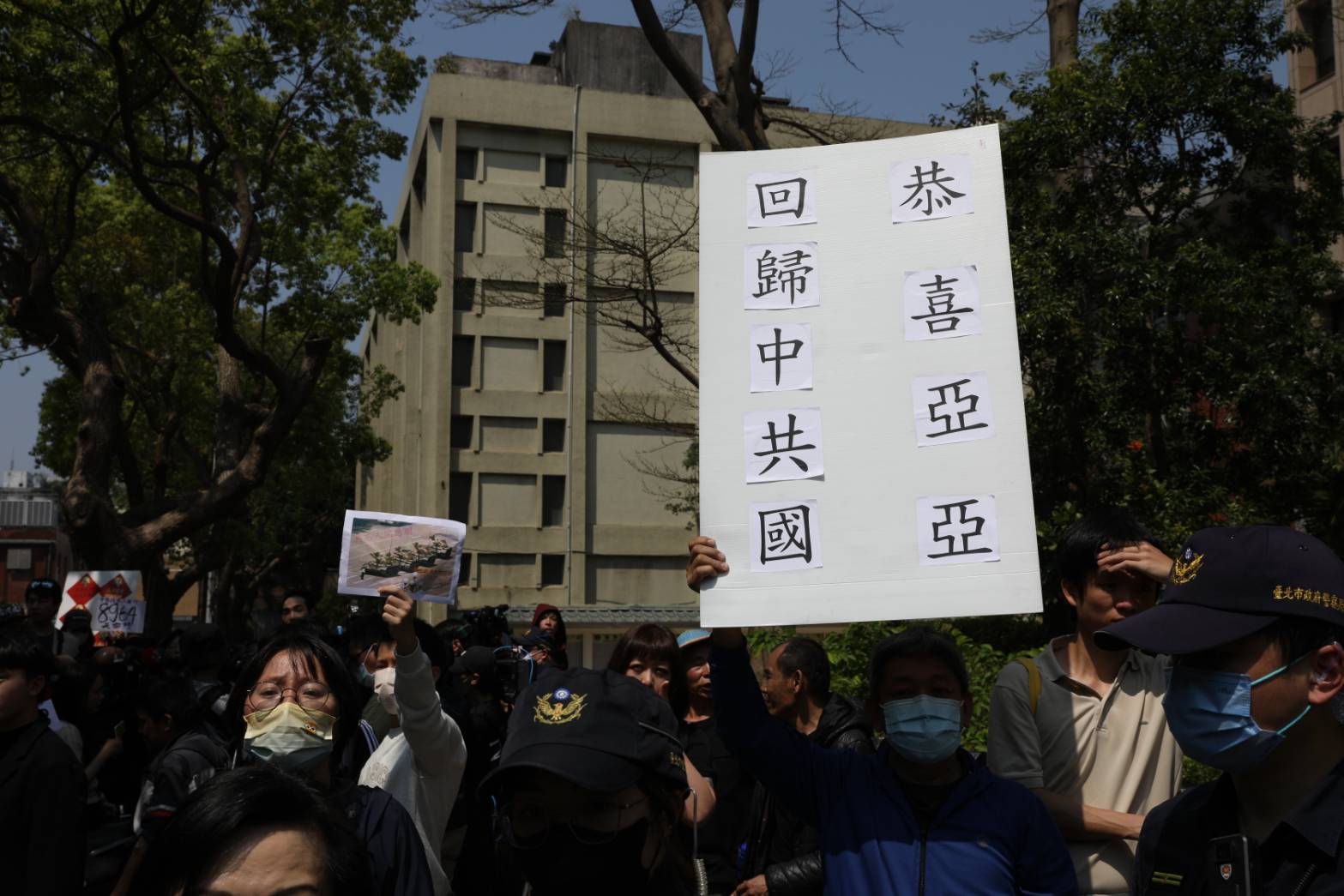 群眾舉牌「恭喜亞亞回歸中共國」。