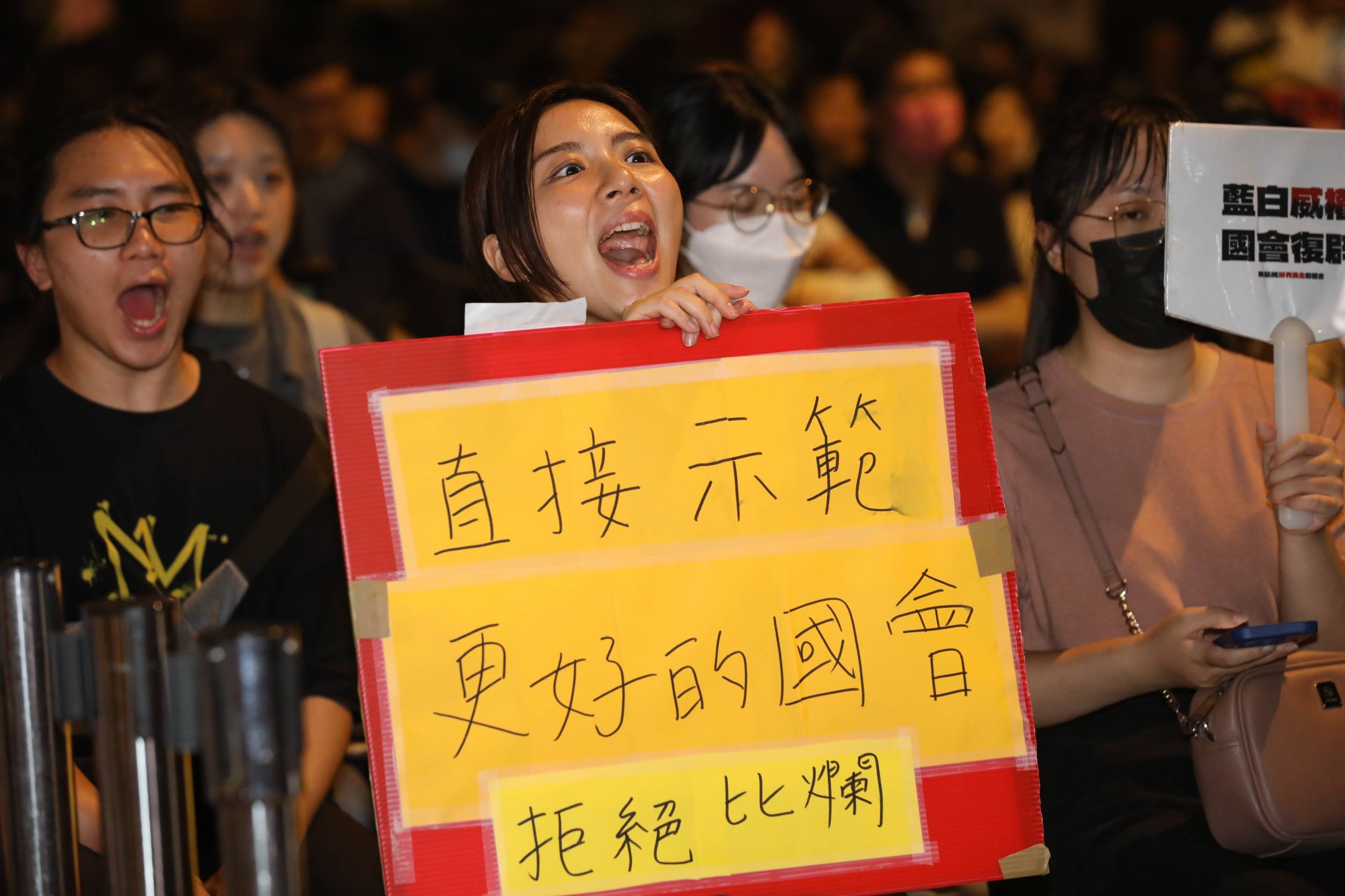 民眾手寫「直接示範更好的國會」手板，呼籲國會拒絕比爛。
