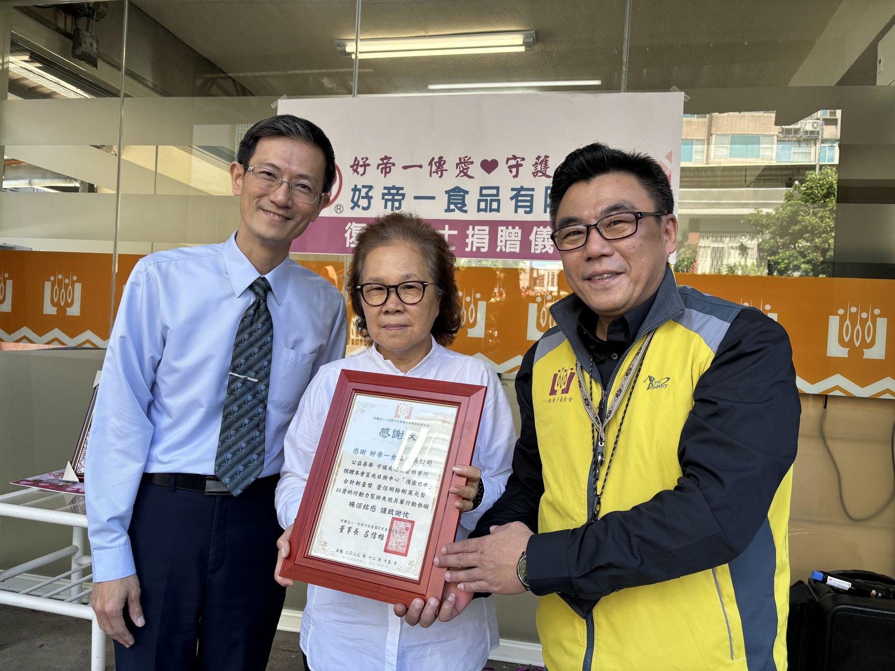 一粒麥子基金會副執行長張竣傑（右）回贈感謝狀給好帝一食品有限公司董事長劉貞秀。（一粒麥子基金會提供）