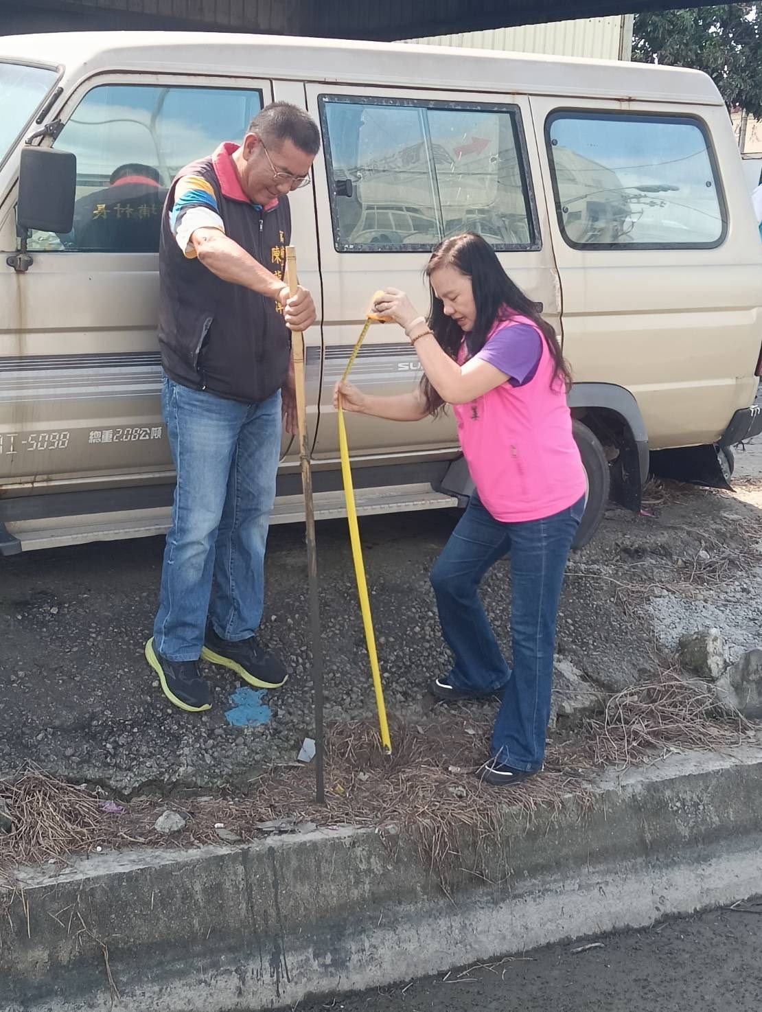 陳龍潭拿尺測量時，一度差點跌入土泥堆，所幸被賴清美及時拉住。（翻攝自賴清美臉書）