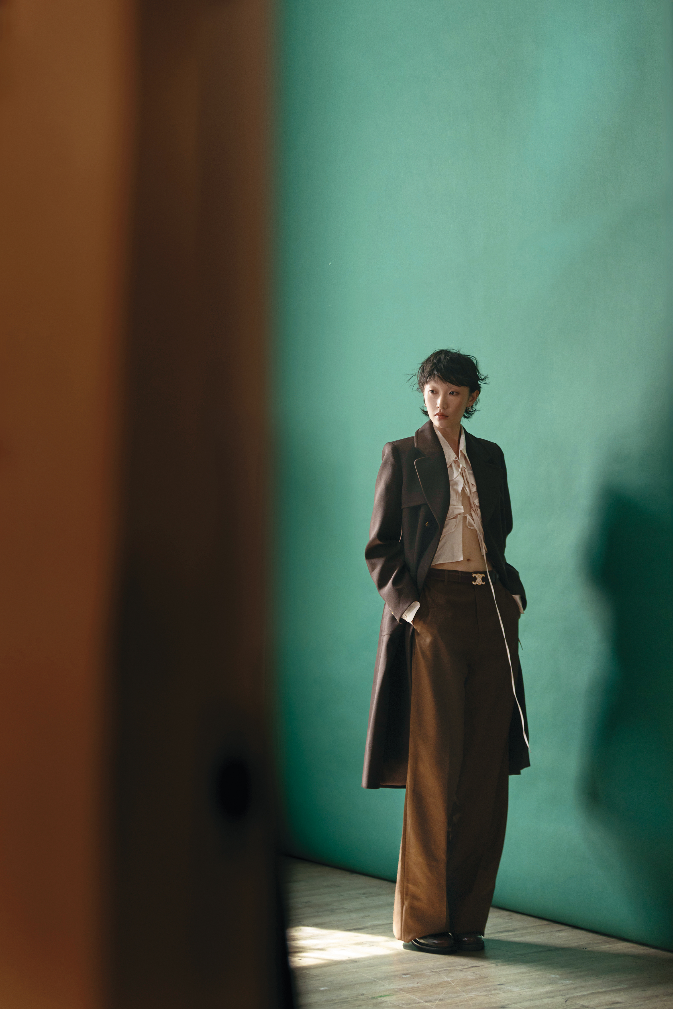長版外套 價格店洽 by SANDRO／粉色襯衫 價格店洽 by PRADA／棕色長褲 價格店洽 by GUCCI／棕色樂福鞋 價格店洽 by Maje／耳環 價格店洽 by CELINE／Logo腰帶 價格店洽 by CELINE