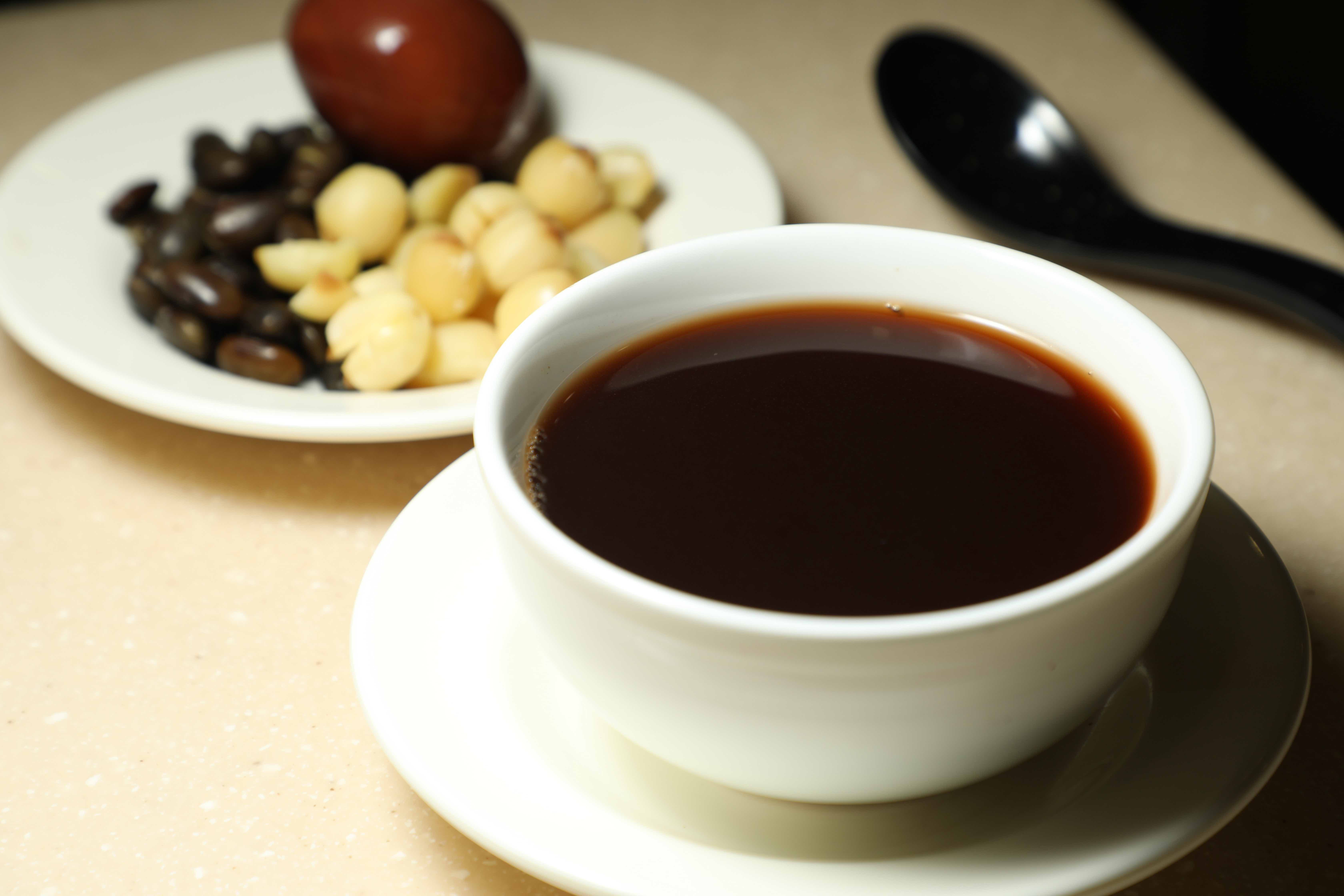 「烏豆桑寄生茶」深褐色近黑色的茶湯微澀會回甘，也經常與蓮子、雞蛋等食材組合搭配。（港幣29元／碗，約NT$120）