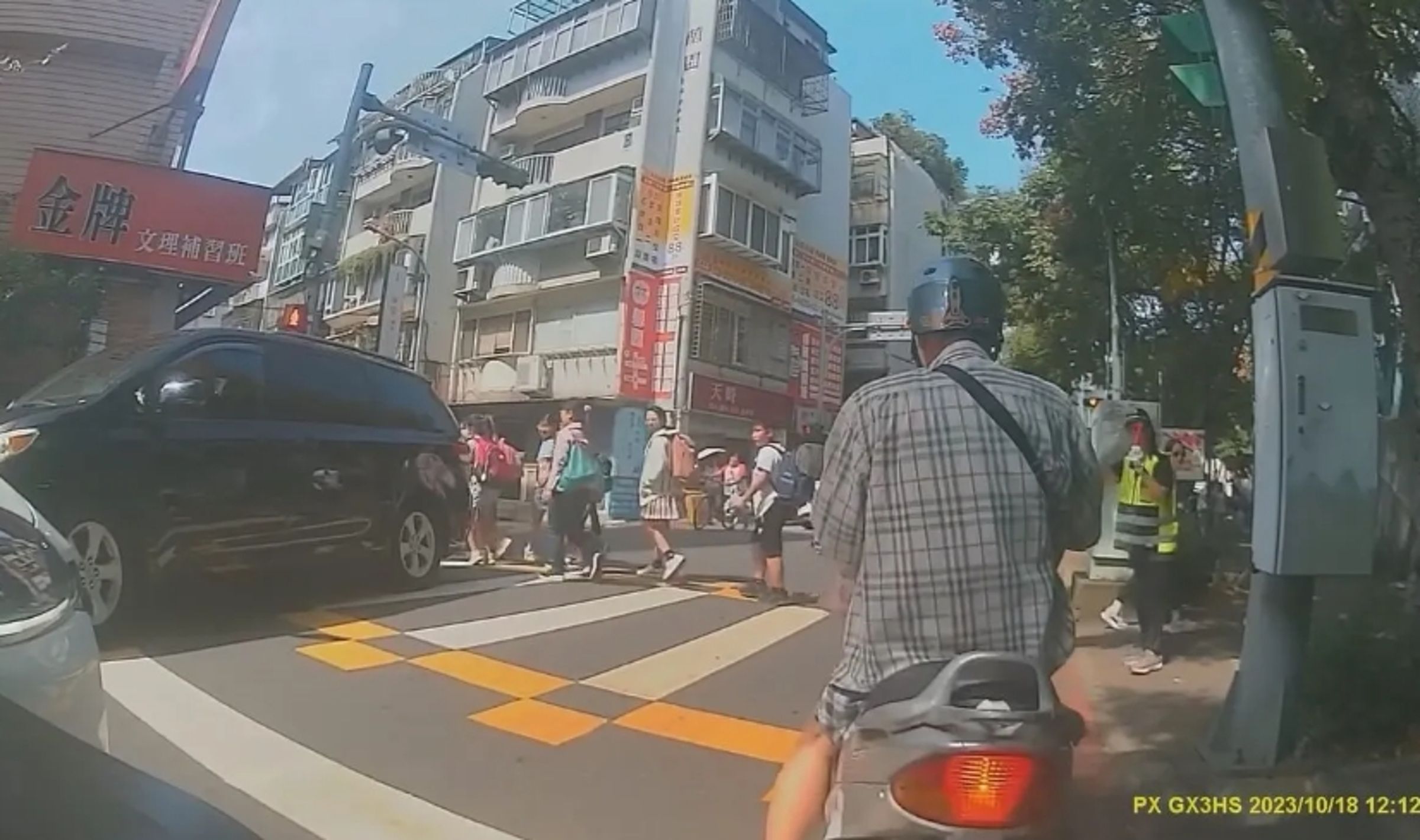 某國小導護志工、師長選擇在行人號誌紅燈時,引導大批學生過馬路,引起爭議。(翻攝自我是士林人~我是北投人~我是大同人臉書社團)