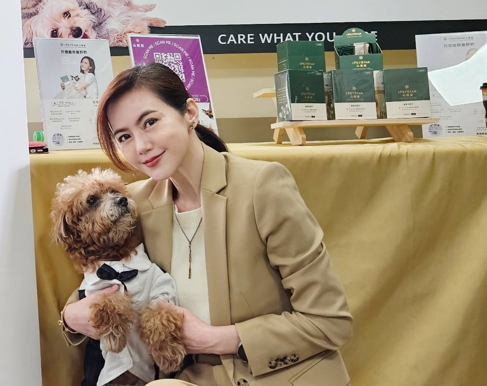 簡沛恩抱著領養的12歲的公司狗ㄎㄡㄎㄡ，日前一起盛裝參加與海洋科技大學寵物業經營管理系的寵物長照技術訓練產學合作活動。（心寵星提供）